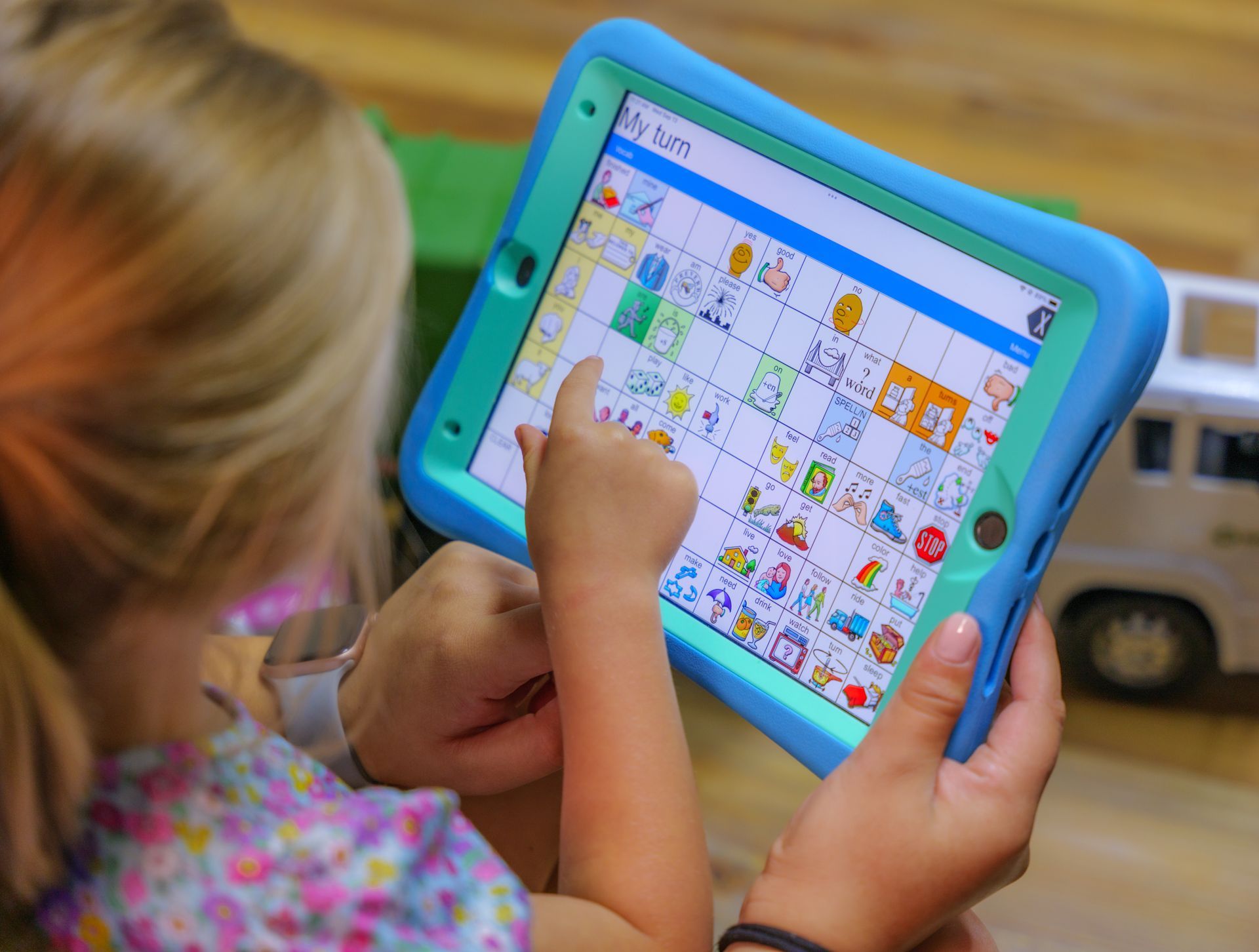 A little girl is playing a game on a tablet