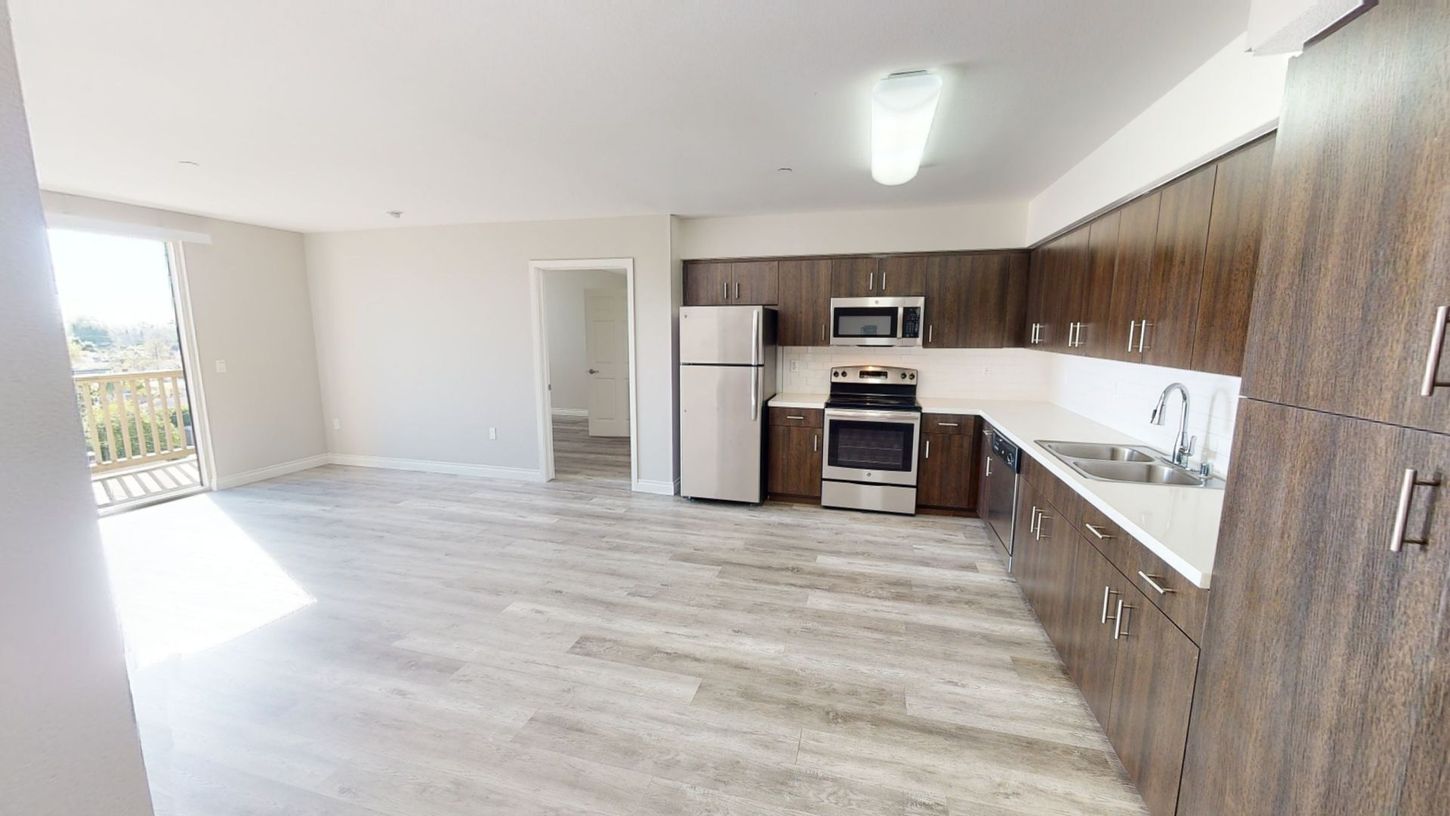 Kitchen with dark wood cabinets, stainless steel appliances, and a light-colored floor.