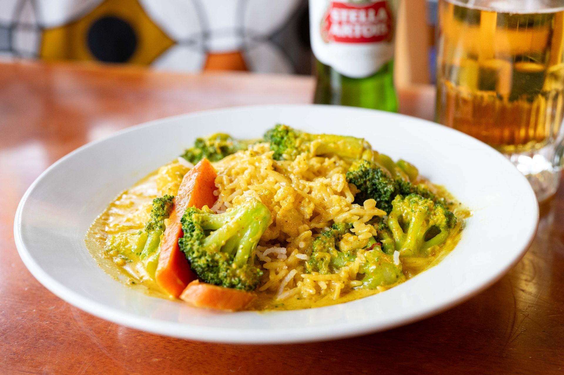 Plate of vegetable fried rice with broccoli and tomato on a restaurant table