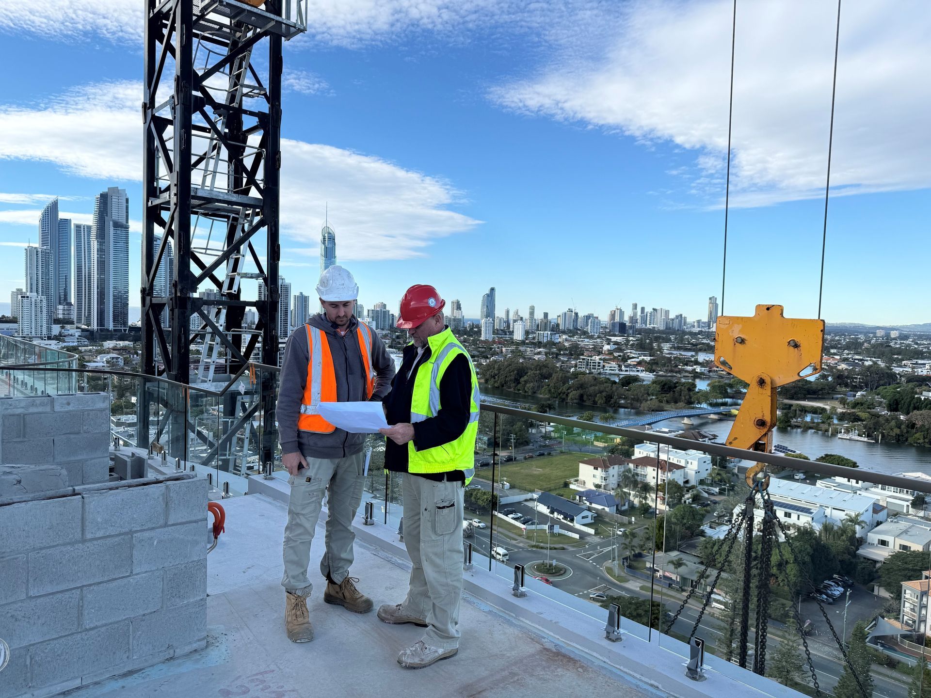 A yellow theodolite is sitting on a tripod on a construction site
