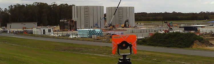 A person is standing in front of a building under construction.