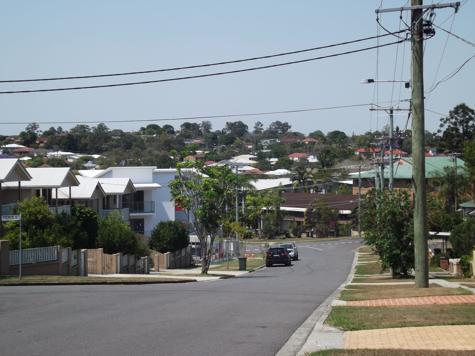 A car is driving down a street in a residential area