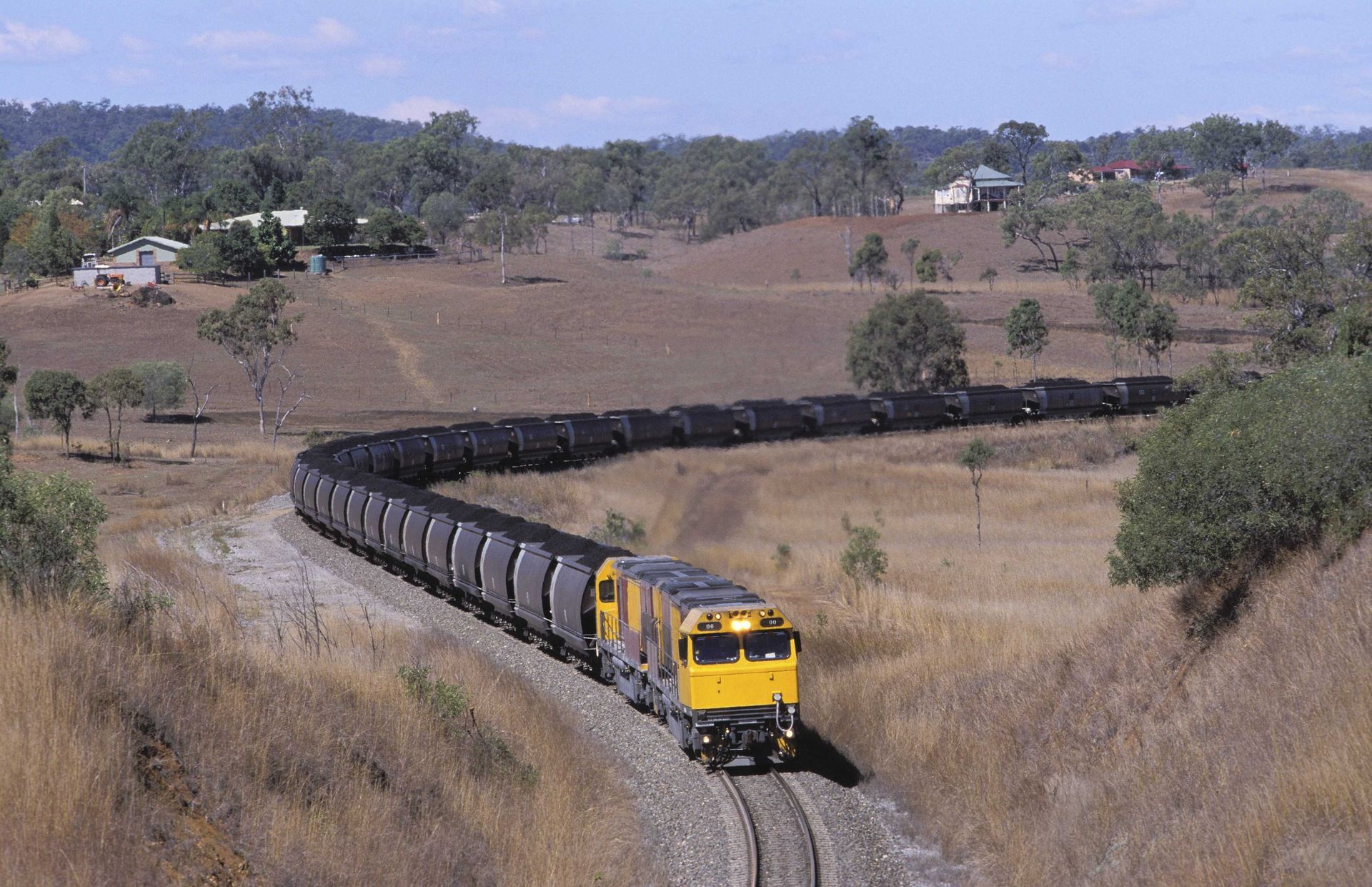 A train is going down the tracks in the countryside