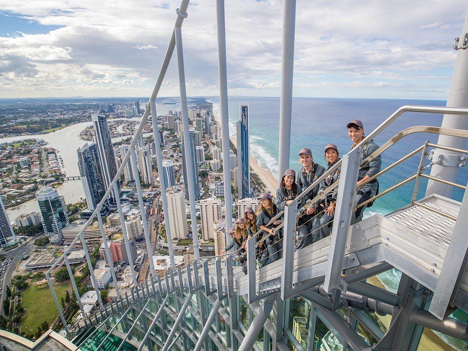 A group of people are sitting on top of a very tall building.