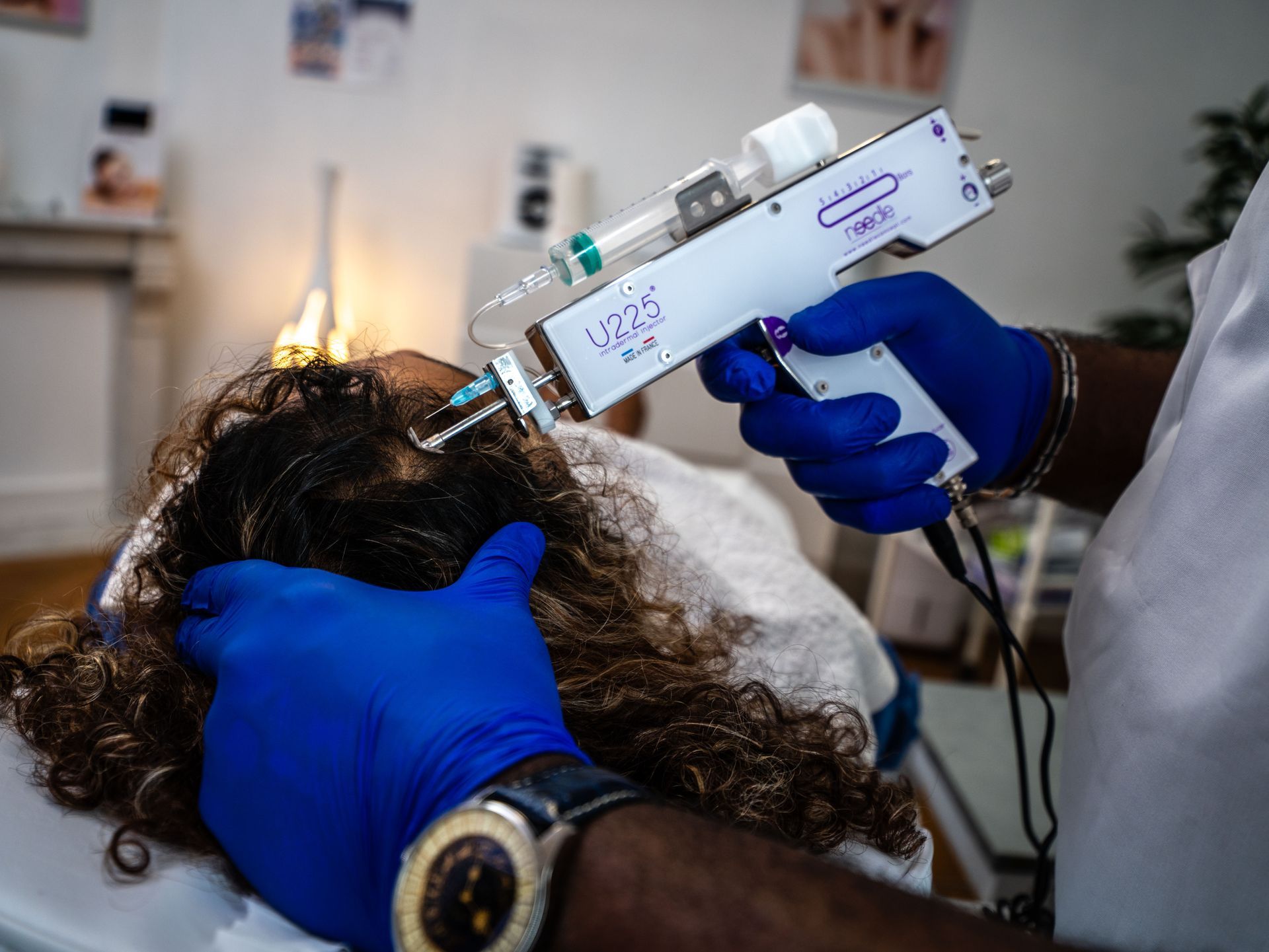 Une personne portant des gants bleus tient un appareil sur lequel est écrit « derma »