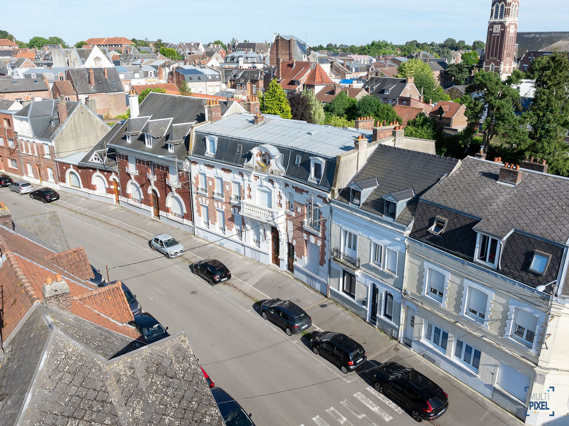 Une vue aérienne d'une ville avec des voitures garées sur le bord de la route