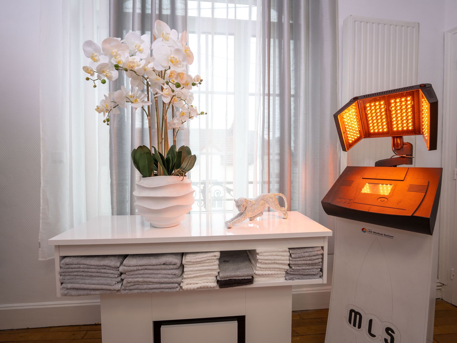 Une table avec un vase de fleurs dessus à côté d'un panneau MLS