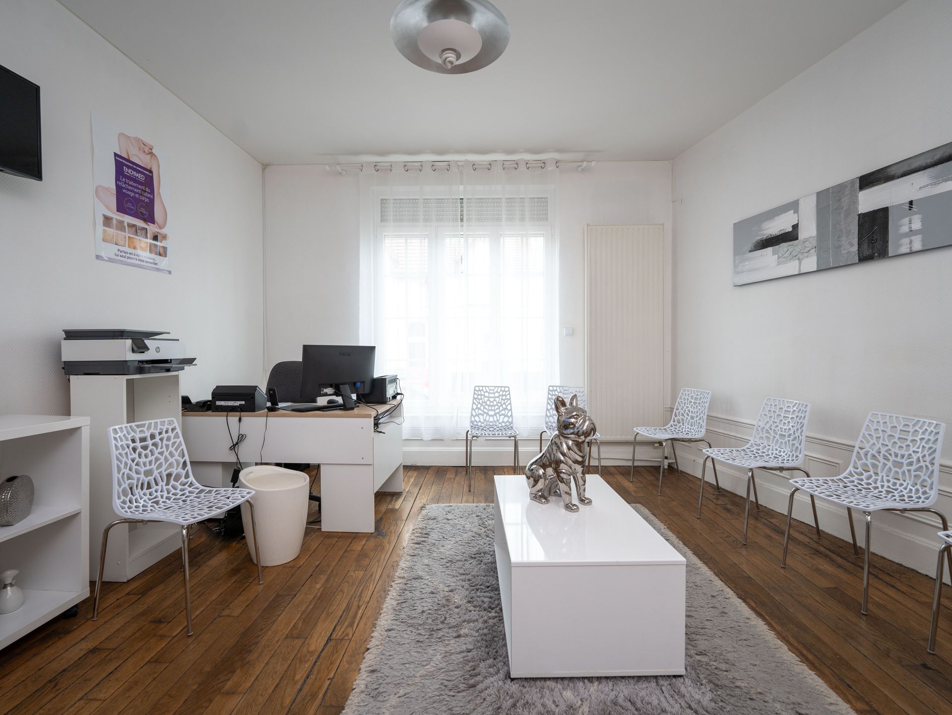 Une salle d'attente avec une table et des chaises blanches