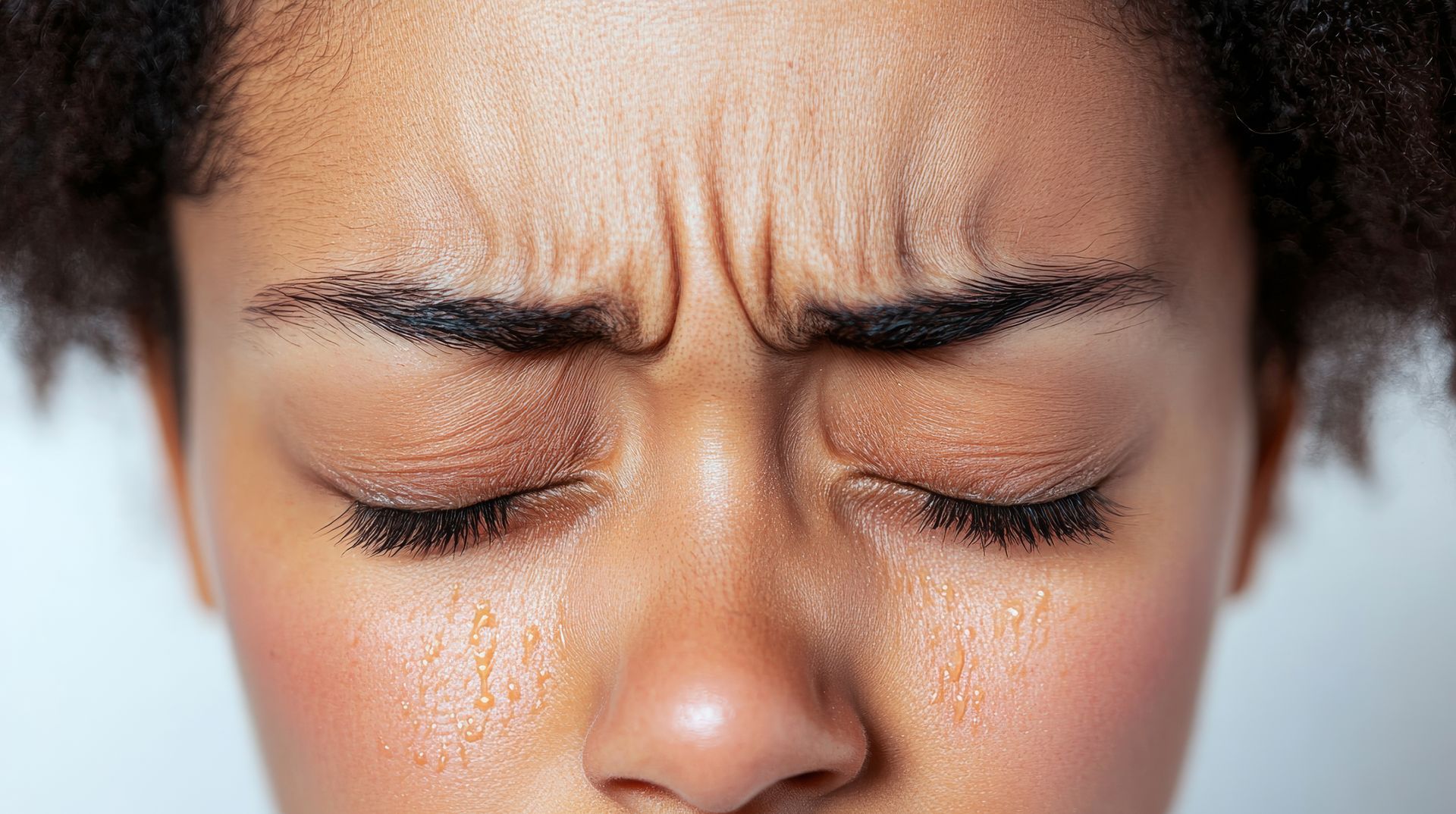 Un gros plan du visage d'une femme avec des rides sur le front.
