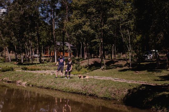 Um homem e uma mulher estão parados perto de um lago em um parque.