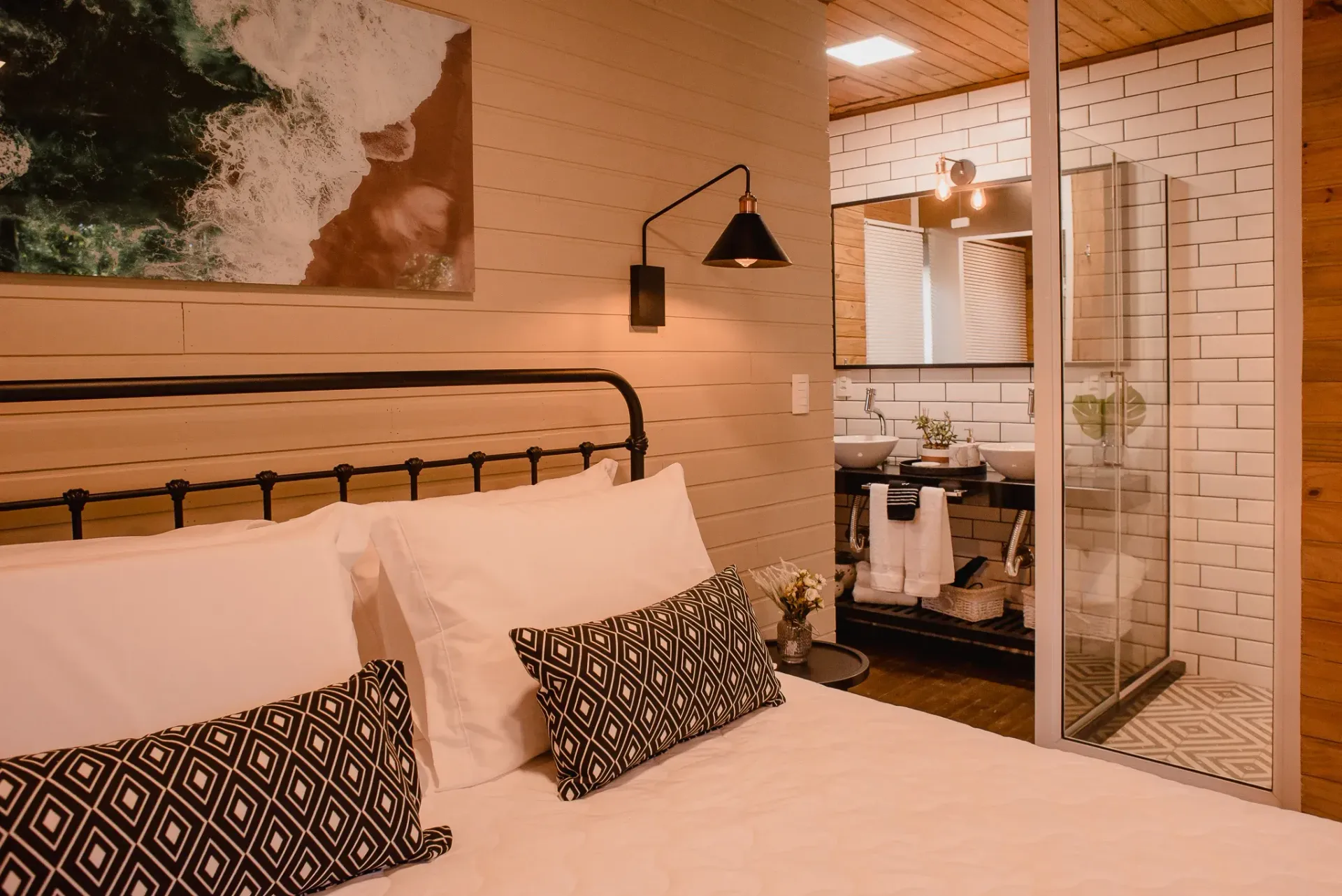Um quarto com uma cama e um banheiro com box amplo.