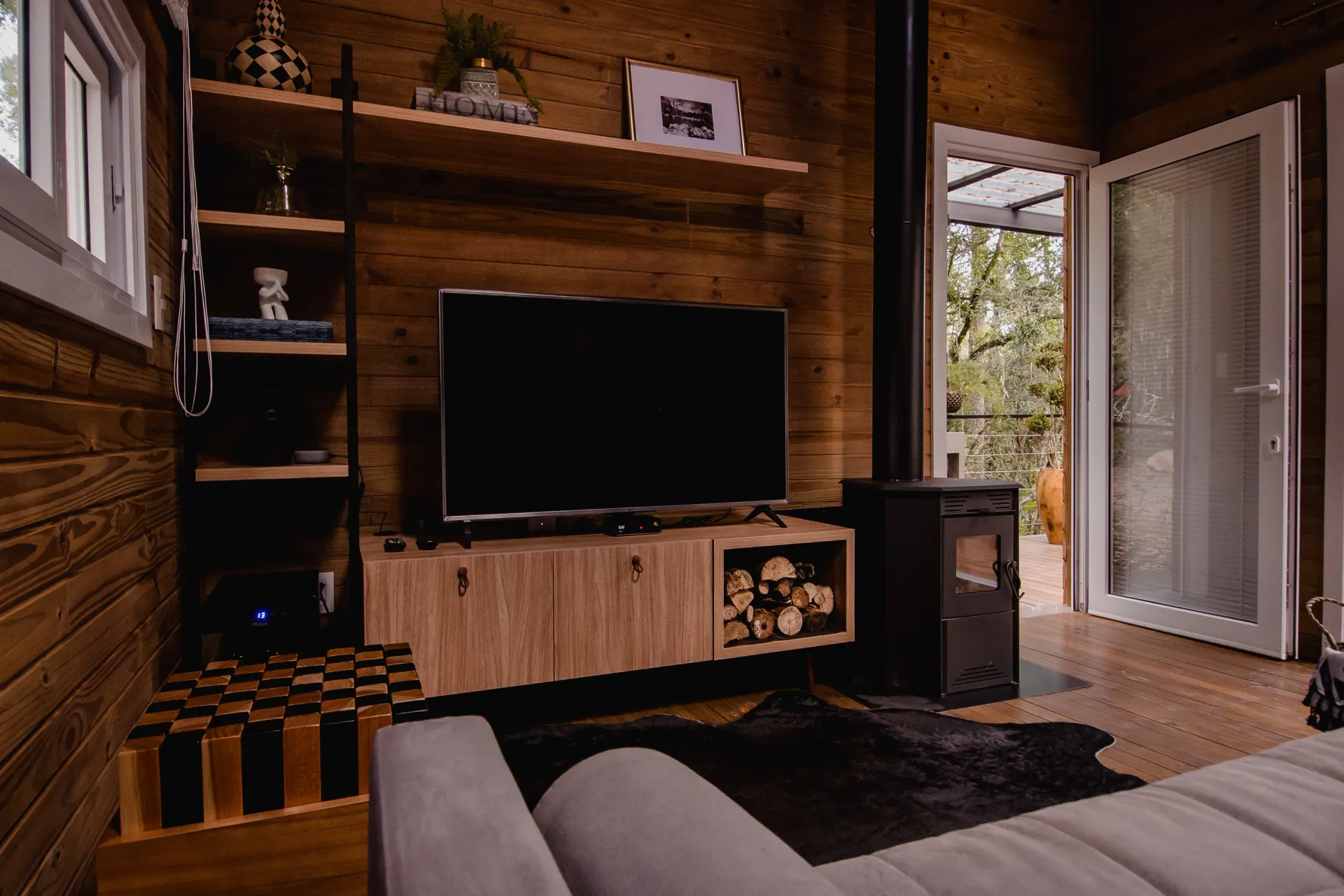 Uma sala de estar com sofá, televisão e lareira.