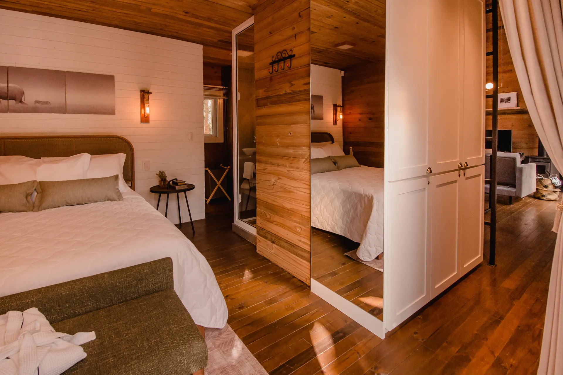 Um quarto com cama, cômoda e espelho.
