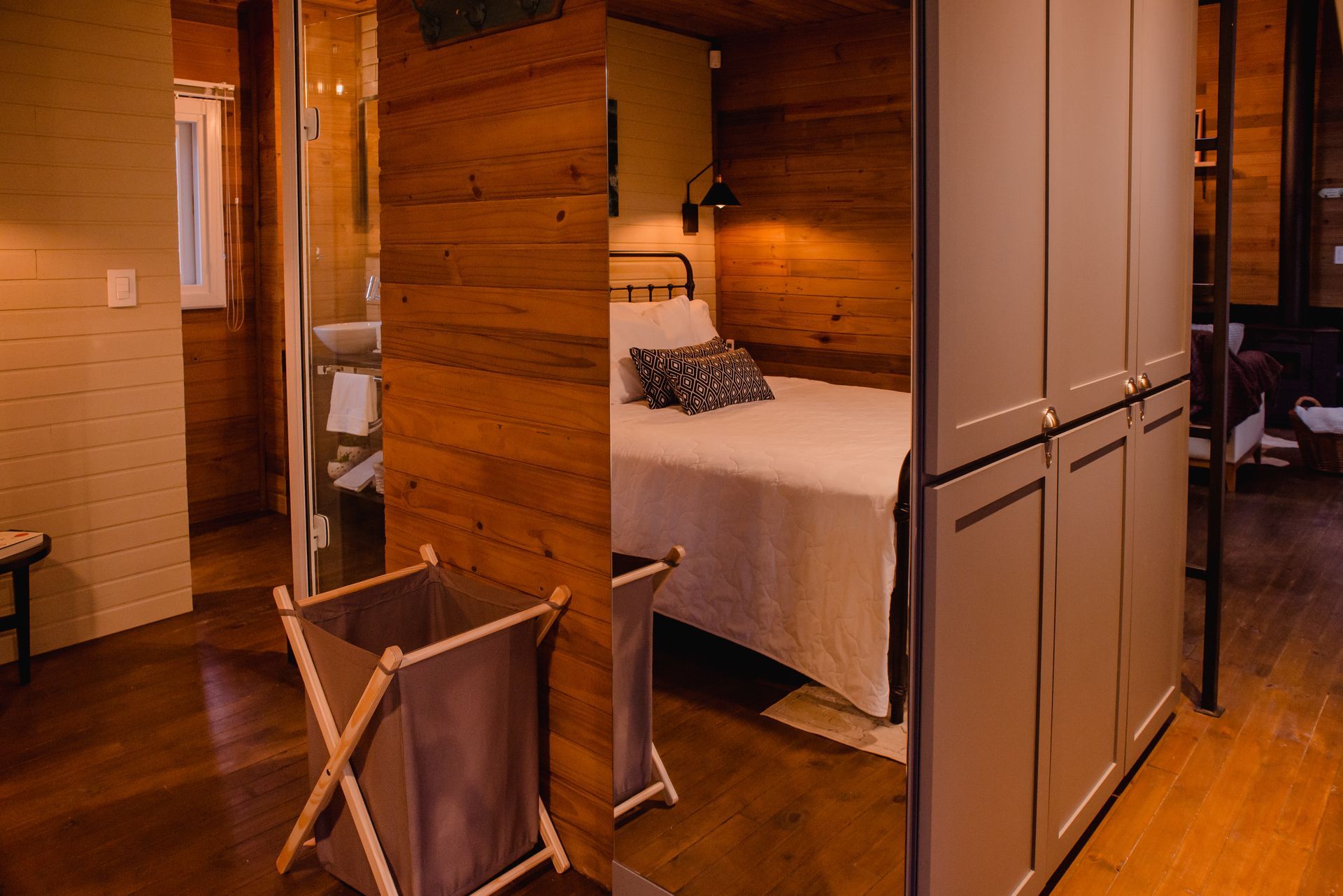 Um quarto com uma cama e um cesto de roupa suja.