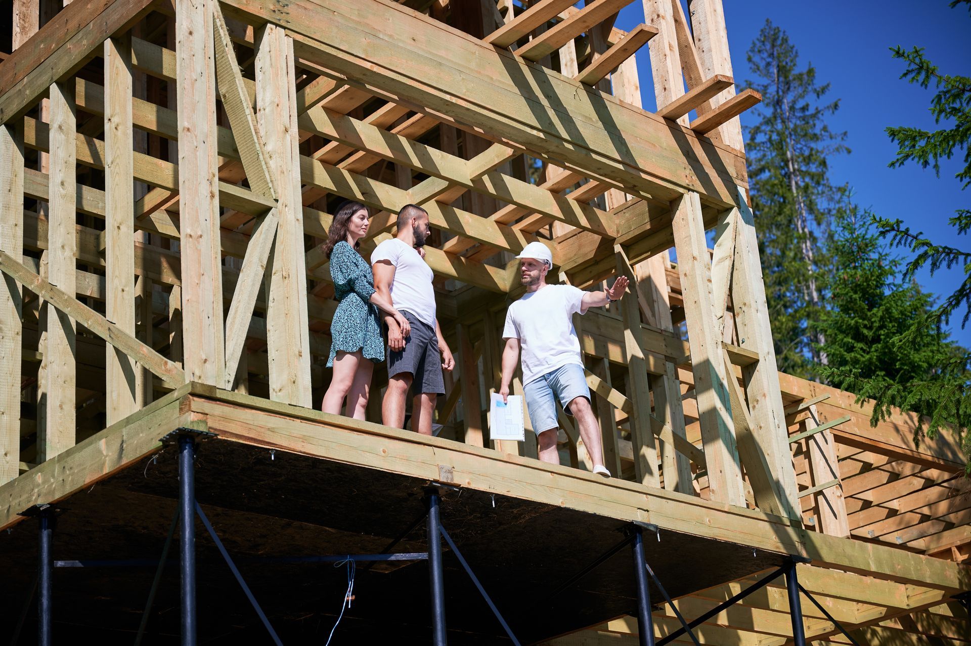 A group of people are standing on top of a wooden building under construction.