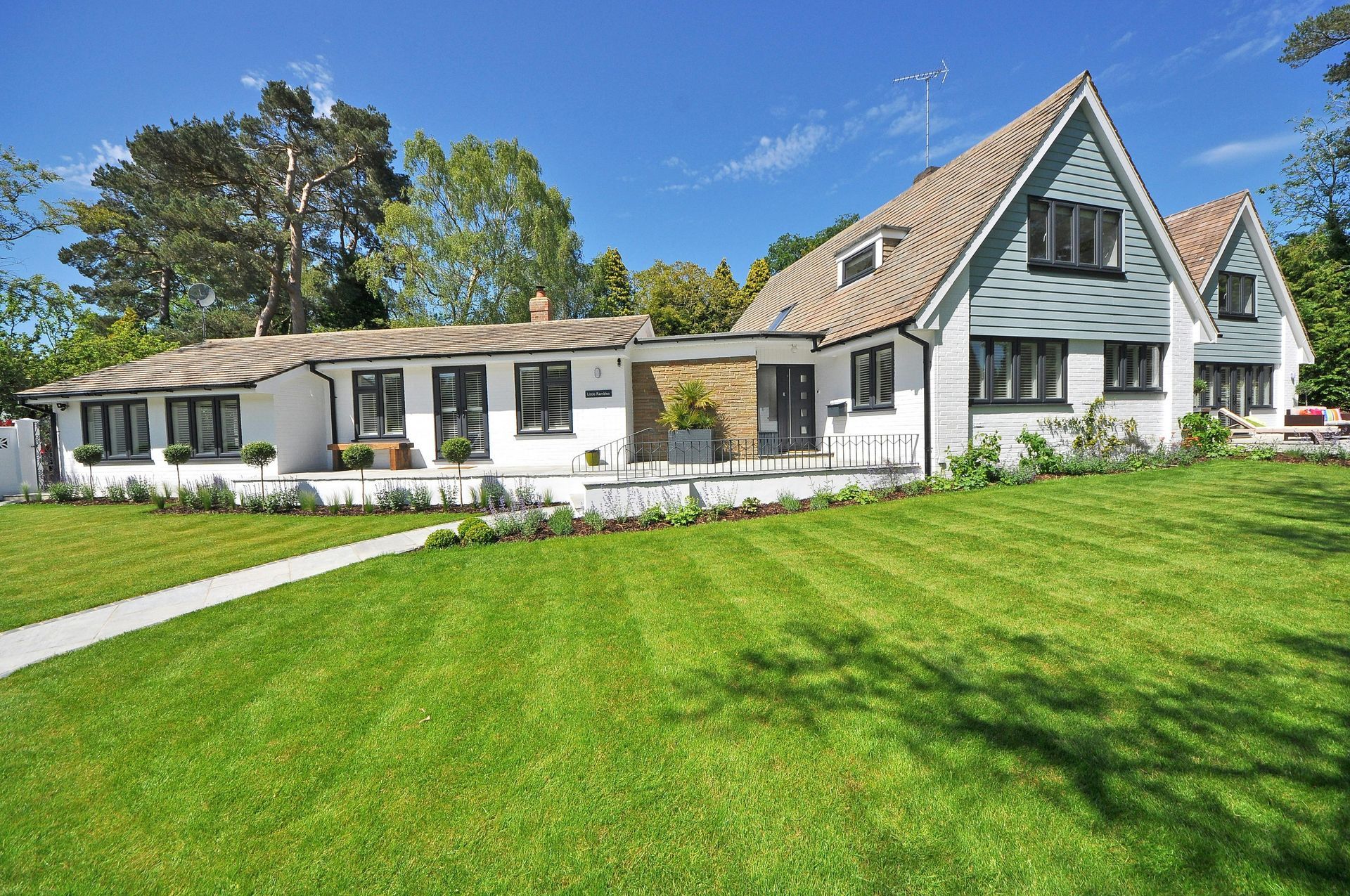 A large white house with a lush green lawn in front of it.