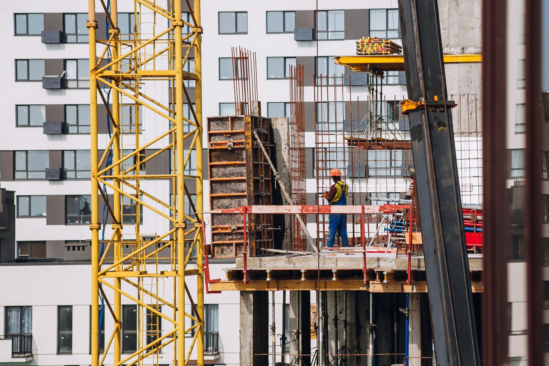 A construction site with a crane in the foreground and a building in the background.