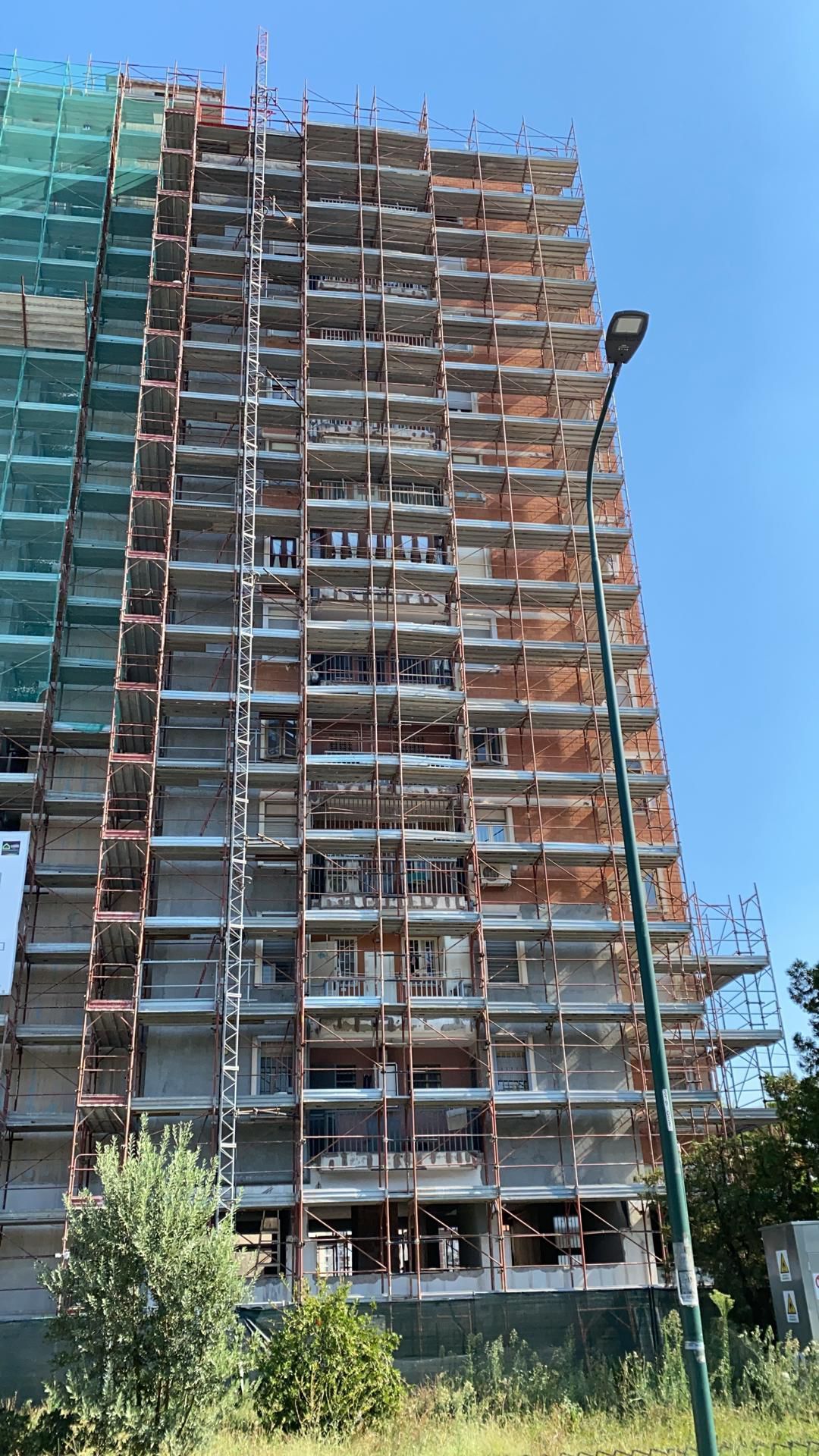 Un alto edificio in costruzione circondato da impalcature.