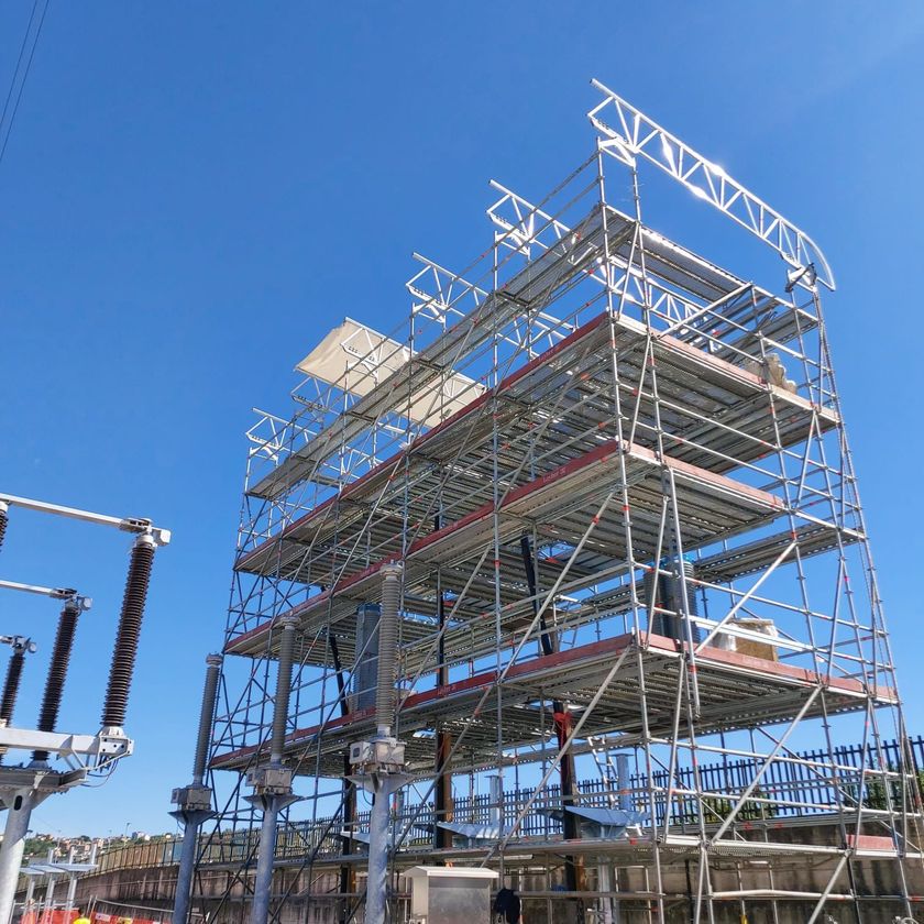 Un edificio in costruzione con impalcature e un cielo azzurro sullo sfondo