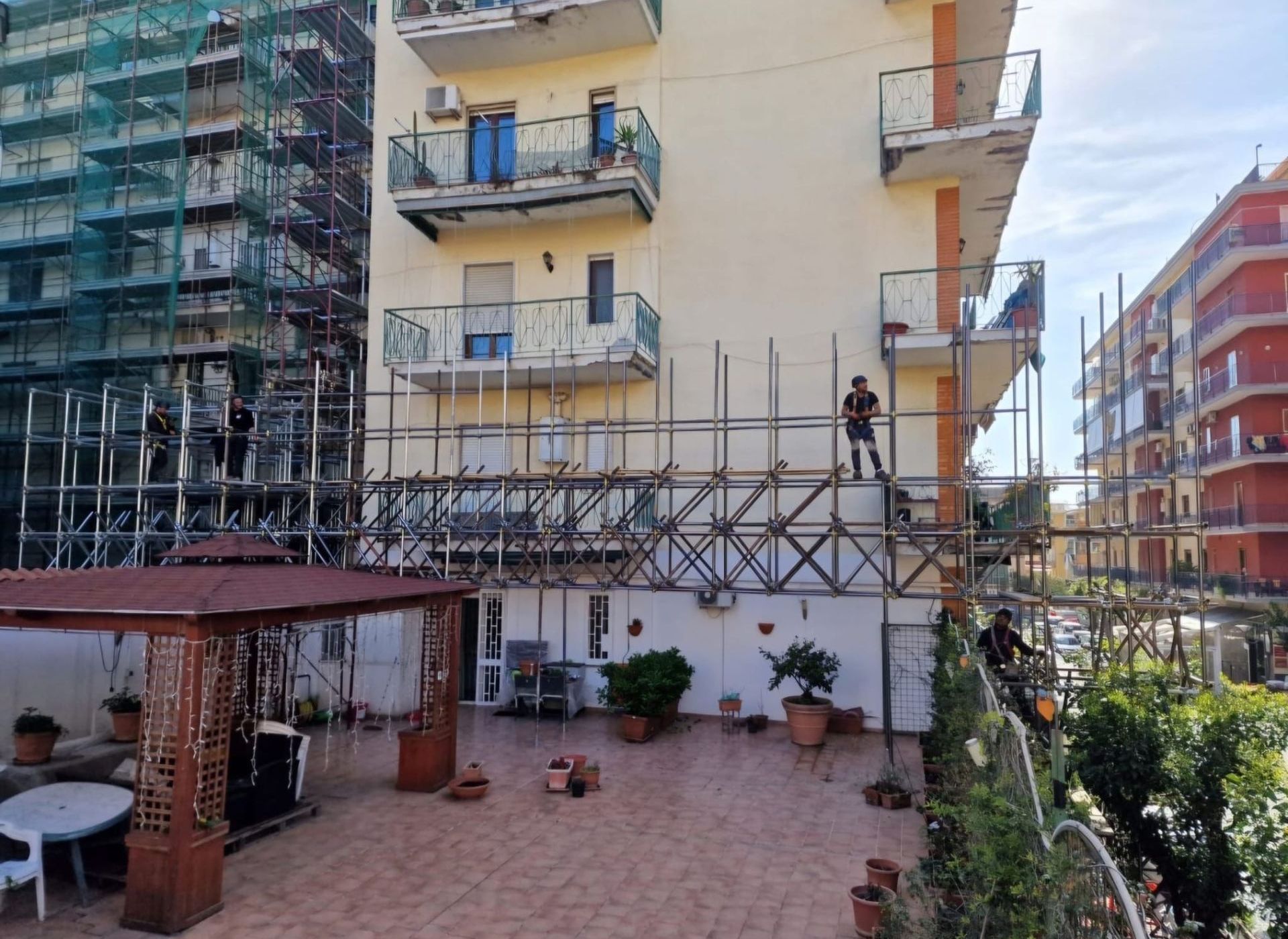 Un uomo è in piedi su un'impalcatura sul lato di un edificio