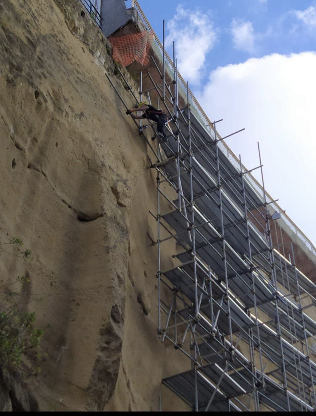Un uomo sta salendo su un'impalcatura sul lato di un edificio
