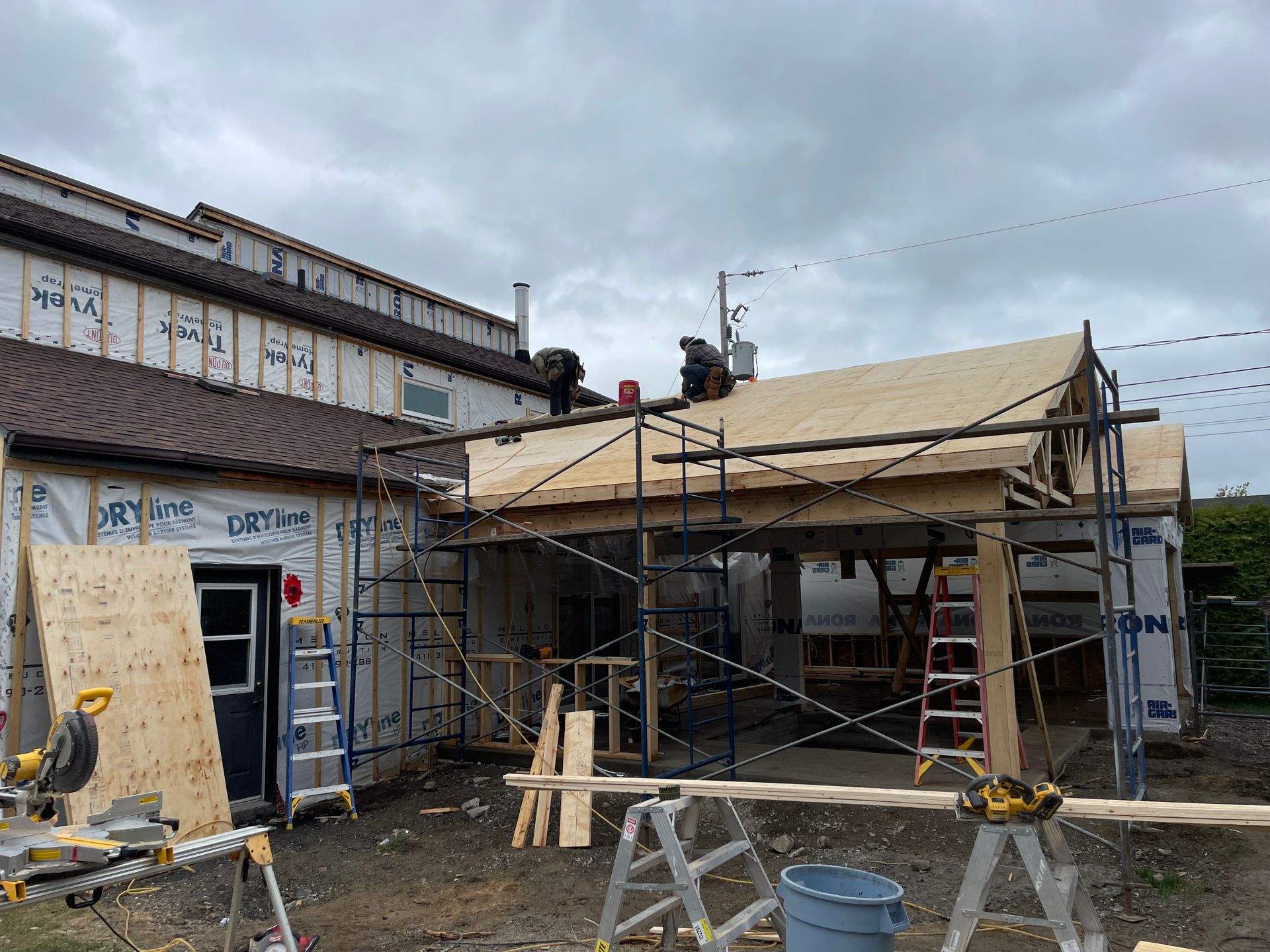 Un bâtiment est en cours de construction avec des échafaudages et des planches de bois.