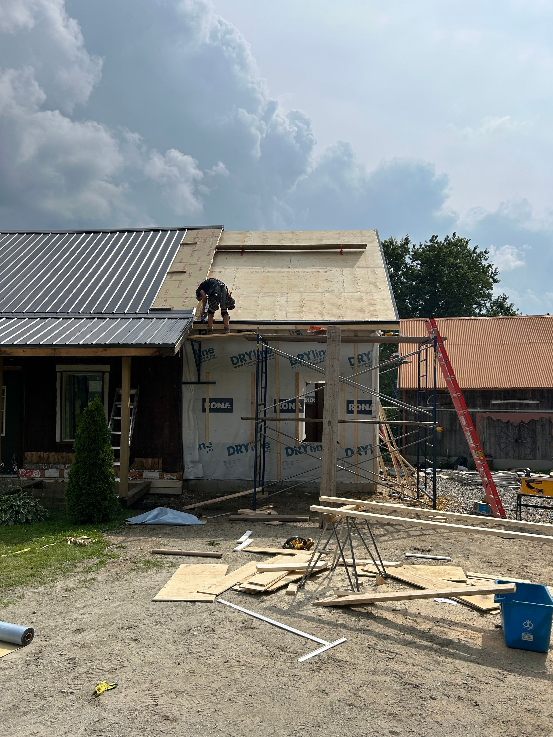 Un homme travaille sur le toit d'une maison en construction.