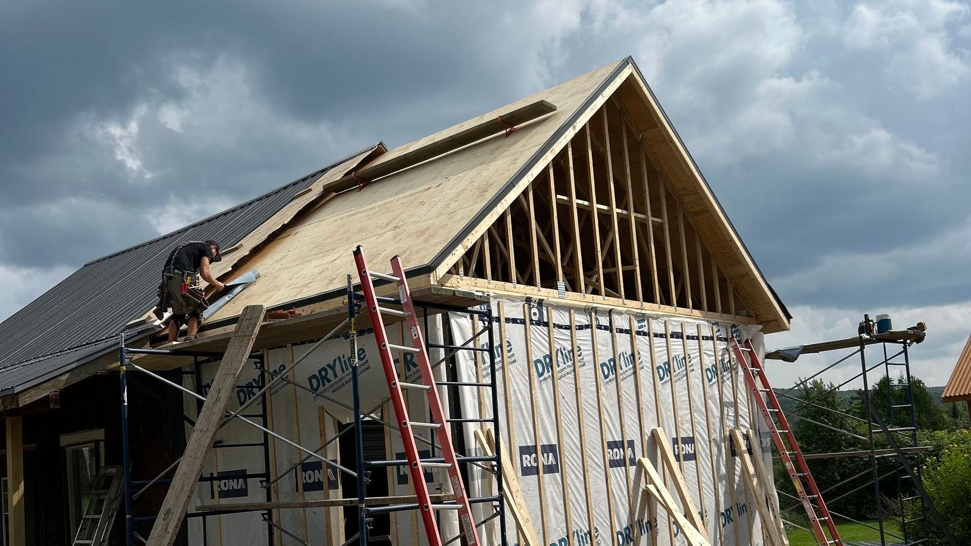 Une maison est en construction avec un toit en cours d'installation.