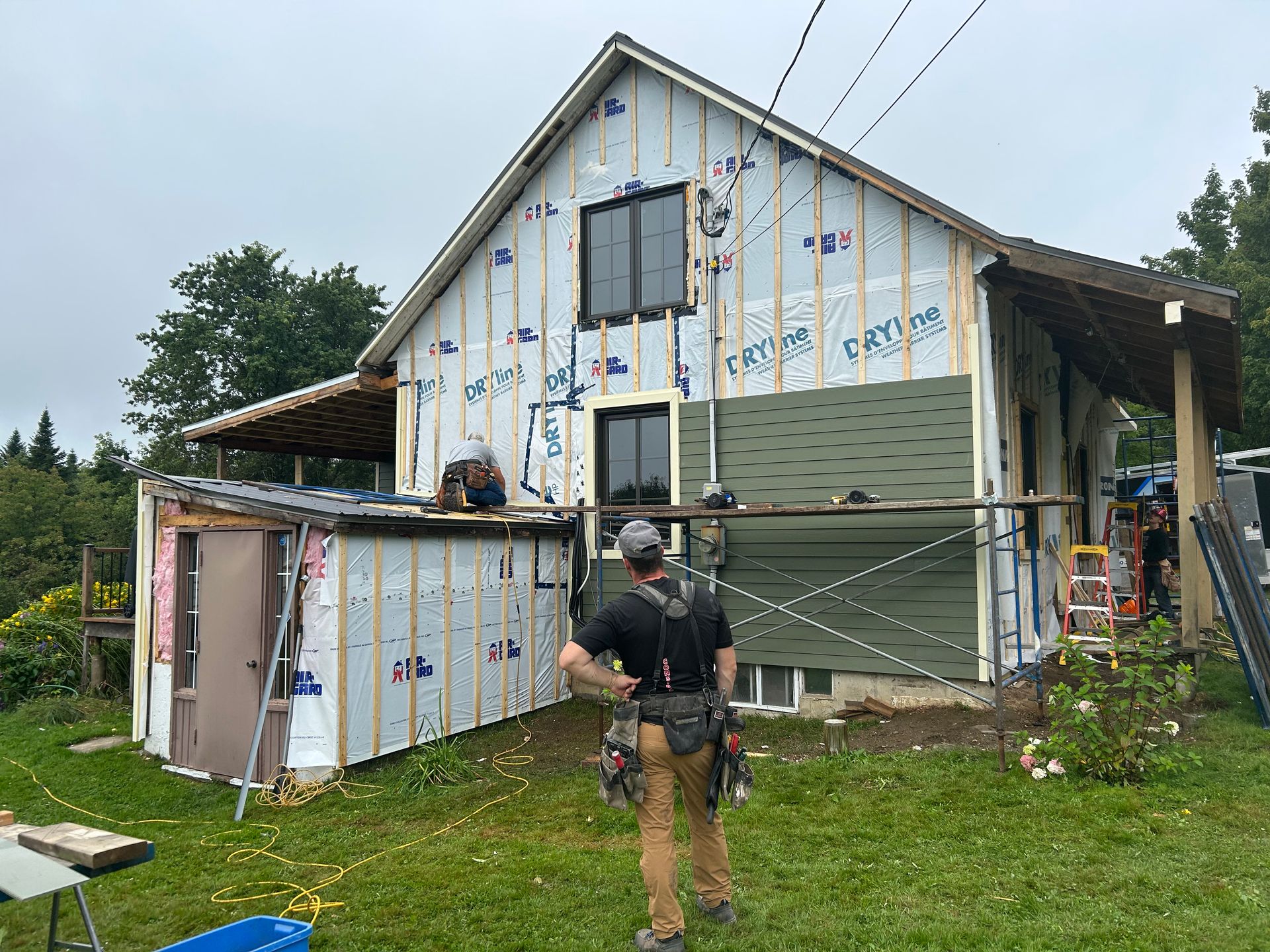 Un homme se tient devant une maison en construction.