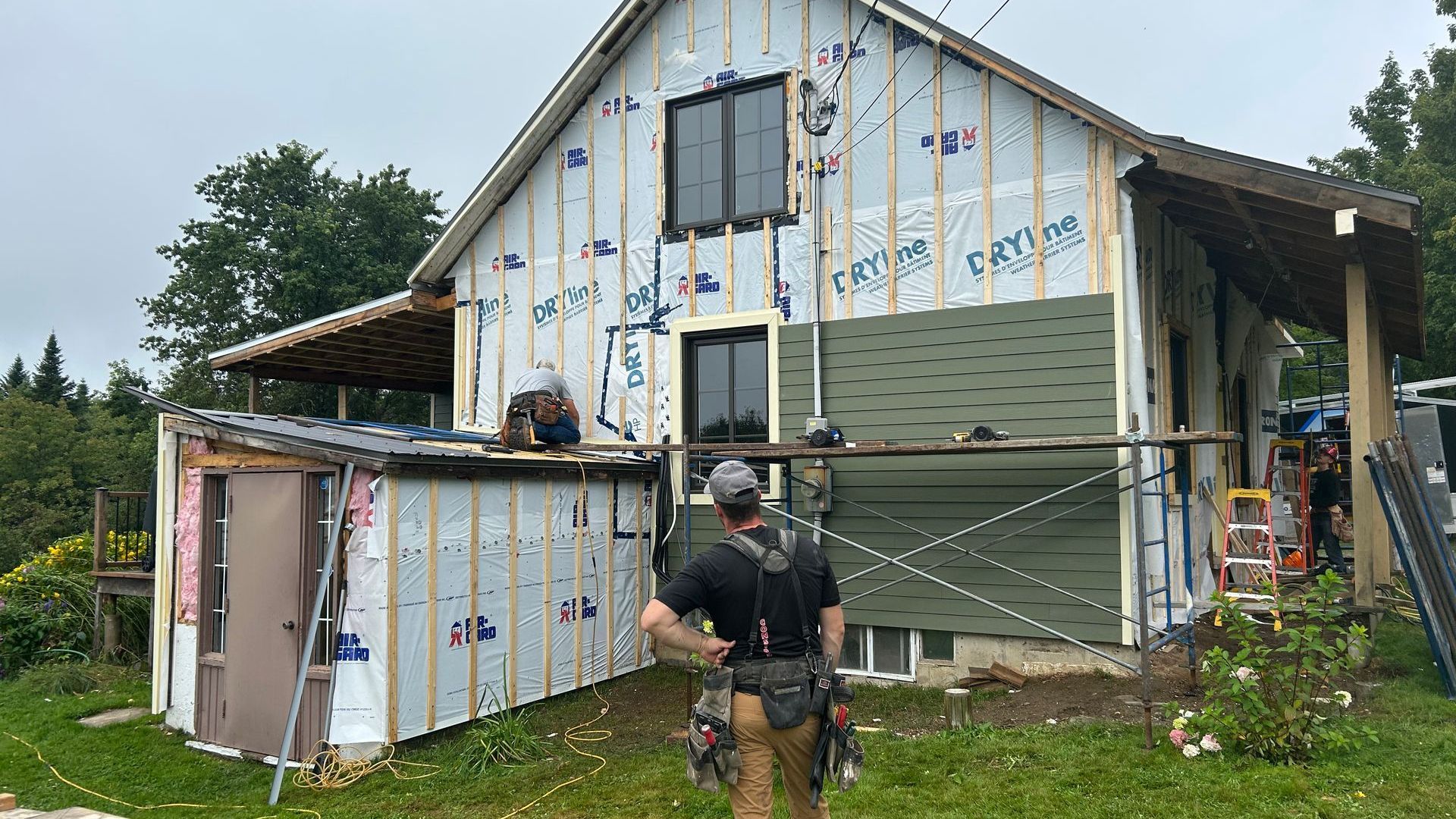 Un homme se tient devant une maison en construction.