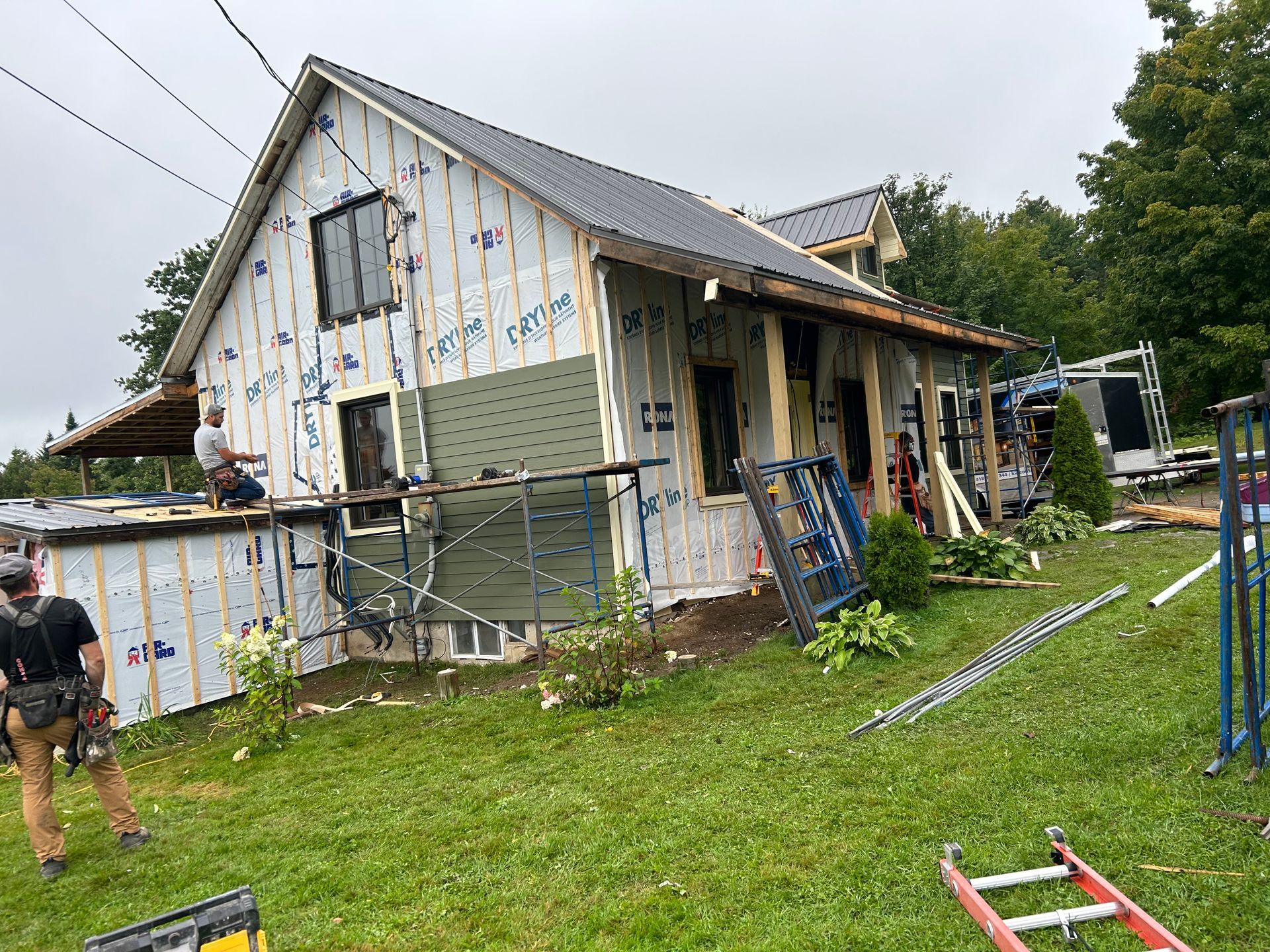Un homme se tient devant une maison en construction.