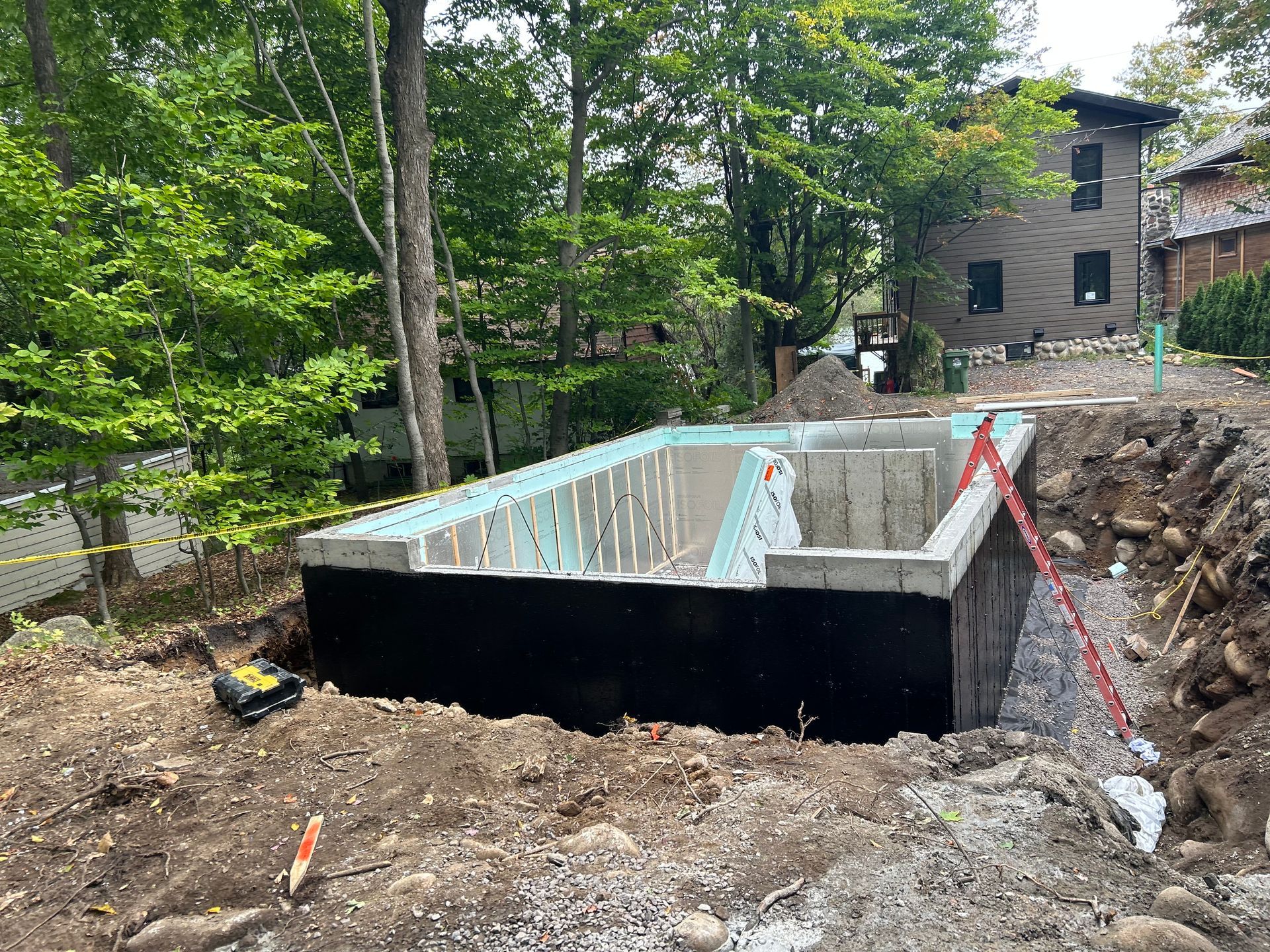 Une grande piscine est en cours de construction dans l'arrière-cour d'une maison.