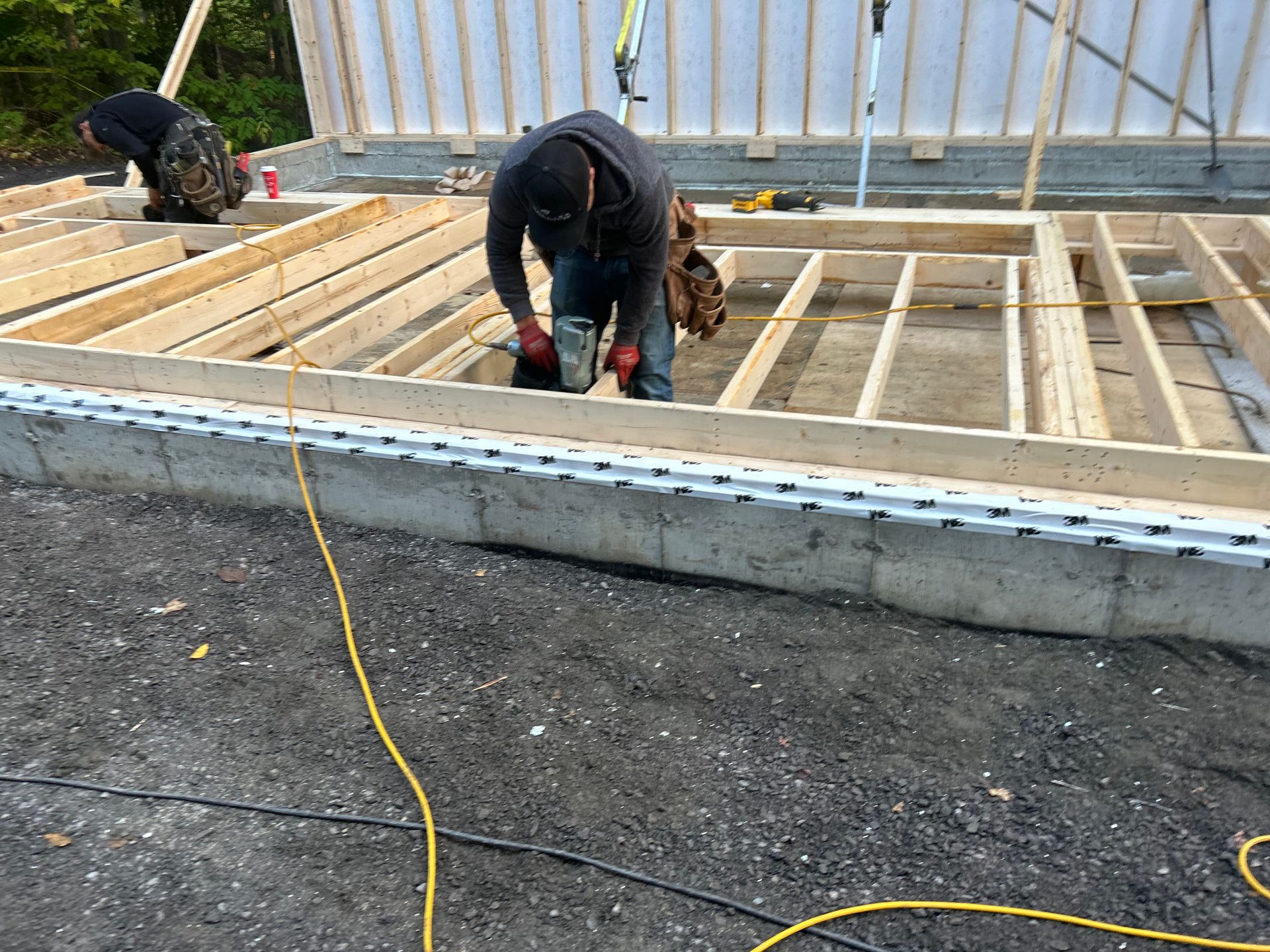 Deux hommes travaillent sur la charpente en bois d'une maison.