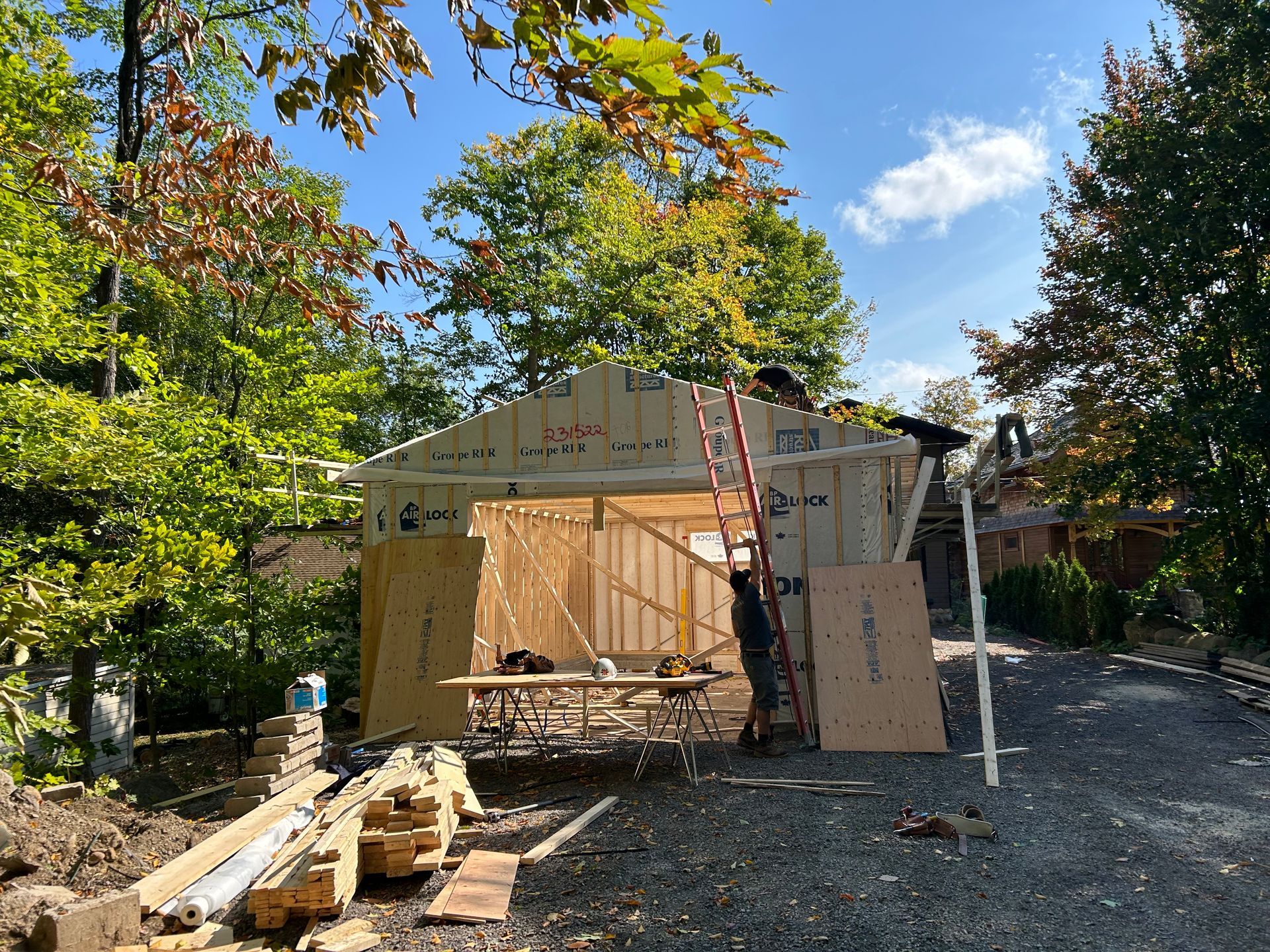 Un homme se tient sur une échelle devant un bâtiment en construction.