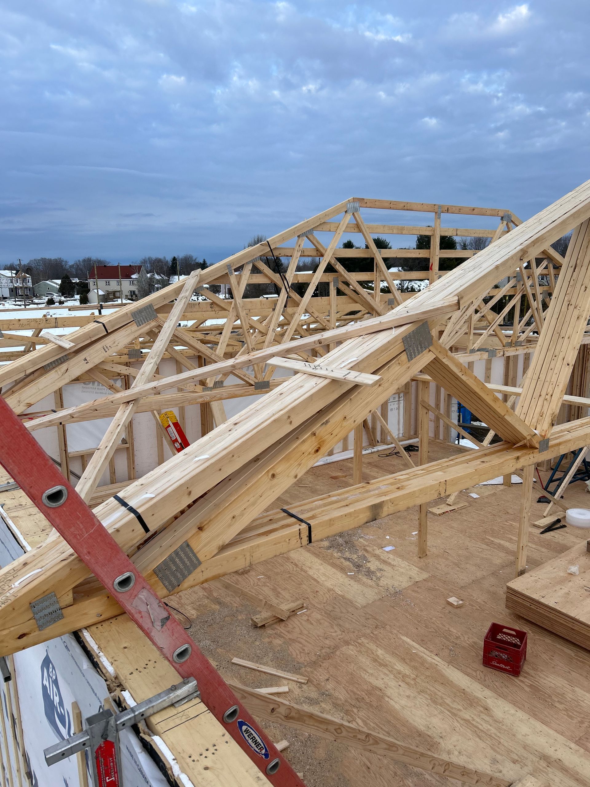 Une échelle est posée sur une structure en bois en construction.