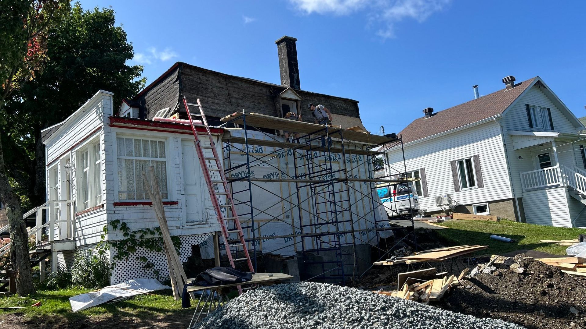 Une maison blanche avec une échelle sur le côté