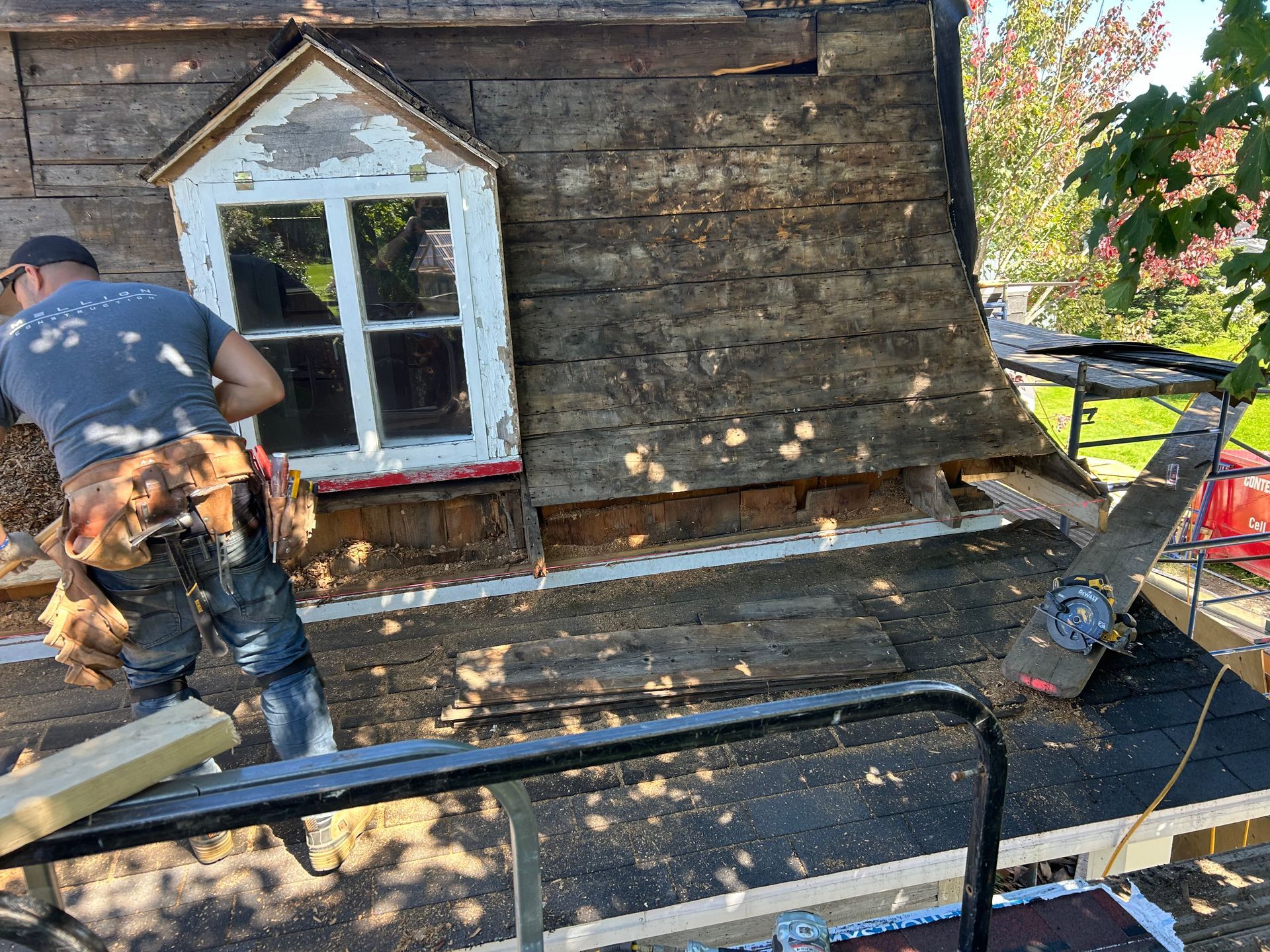 Un homme travaille sur le toit d'une maison.