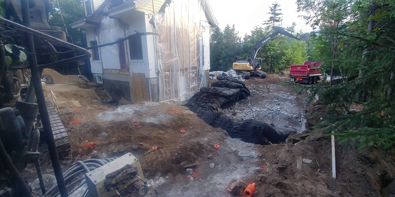 Chantier de construction avec un bâtiment partiellement démoli et des engins de chantier.