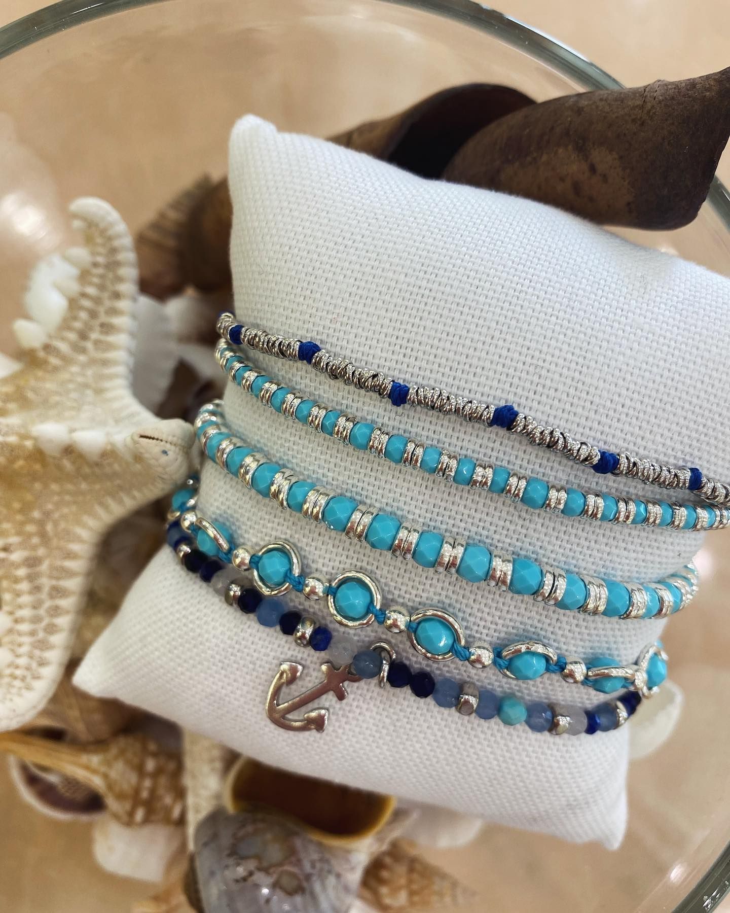 Diversi braccialetti sono impilati uno sopra l'altro su un cuscino bianco