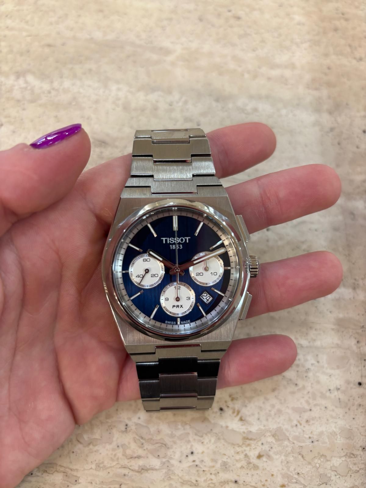 Una donna tiene in mano un orologio d'argento.