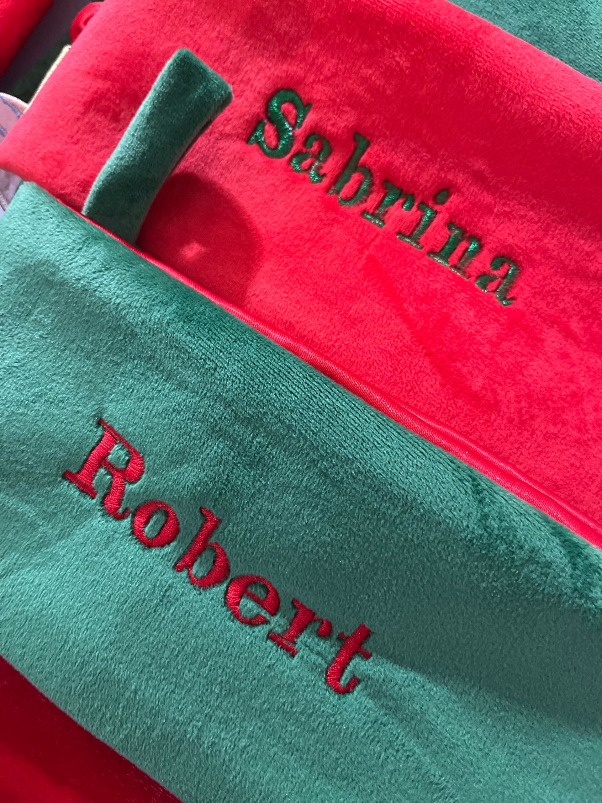 A red and green towel with the name sabrina and robert embroidered on it