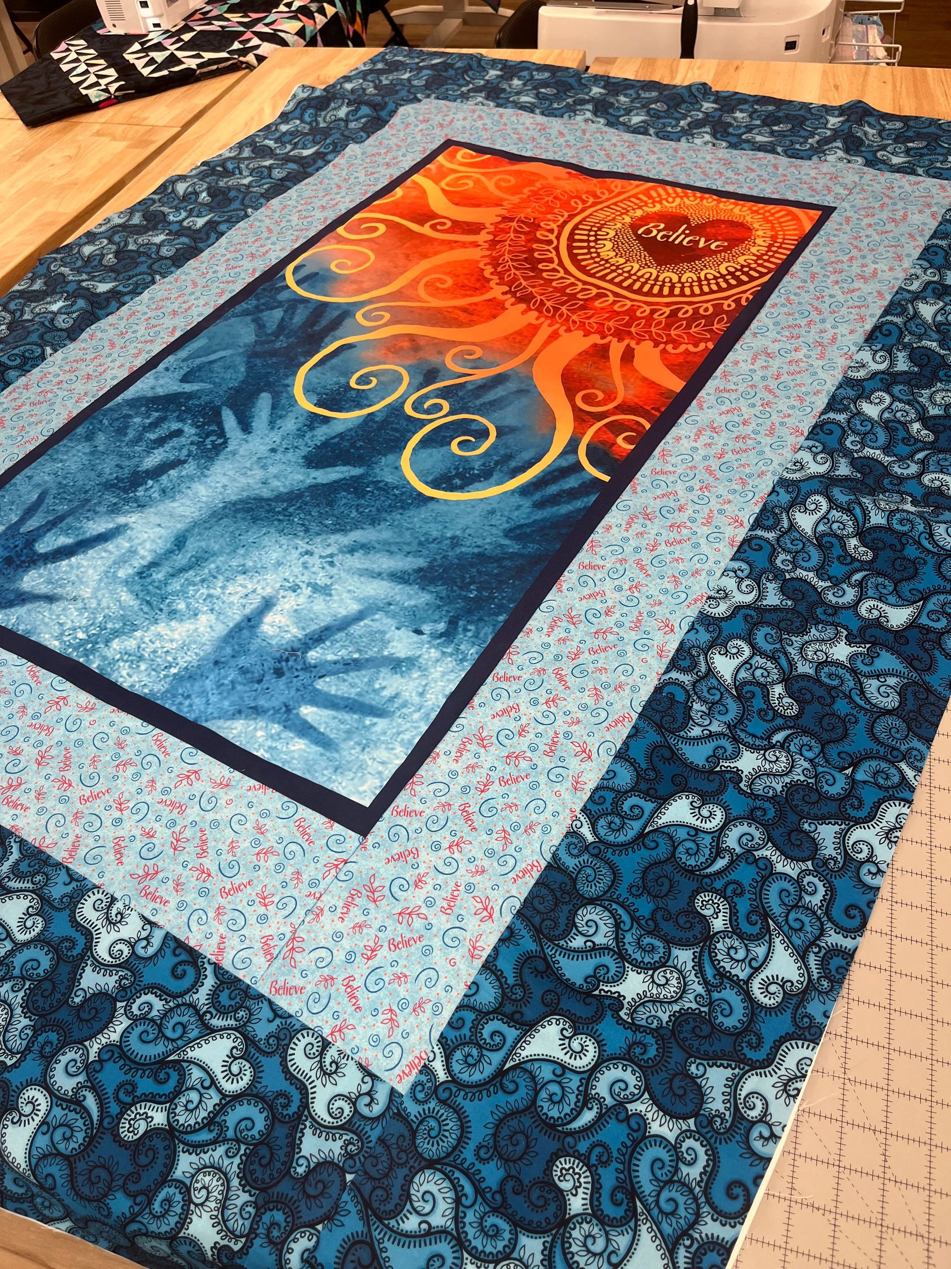 A quilt is sitting on top of a wooden table.