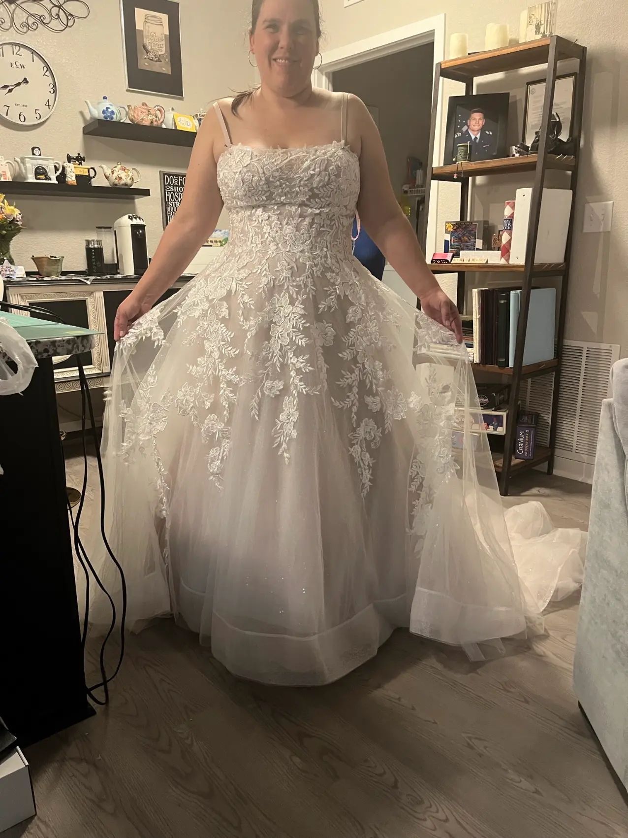 A woman in a wedding dress is standing in a living room