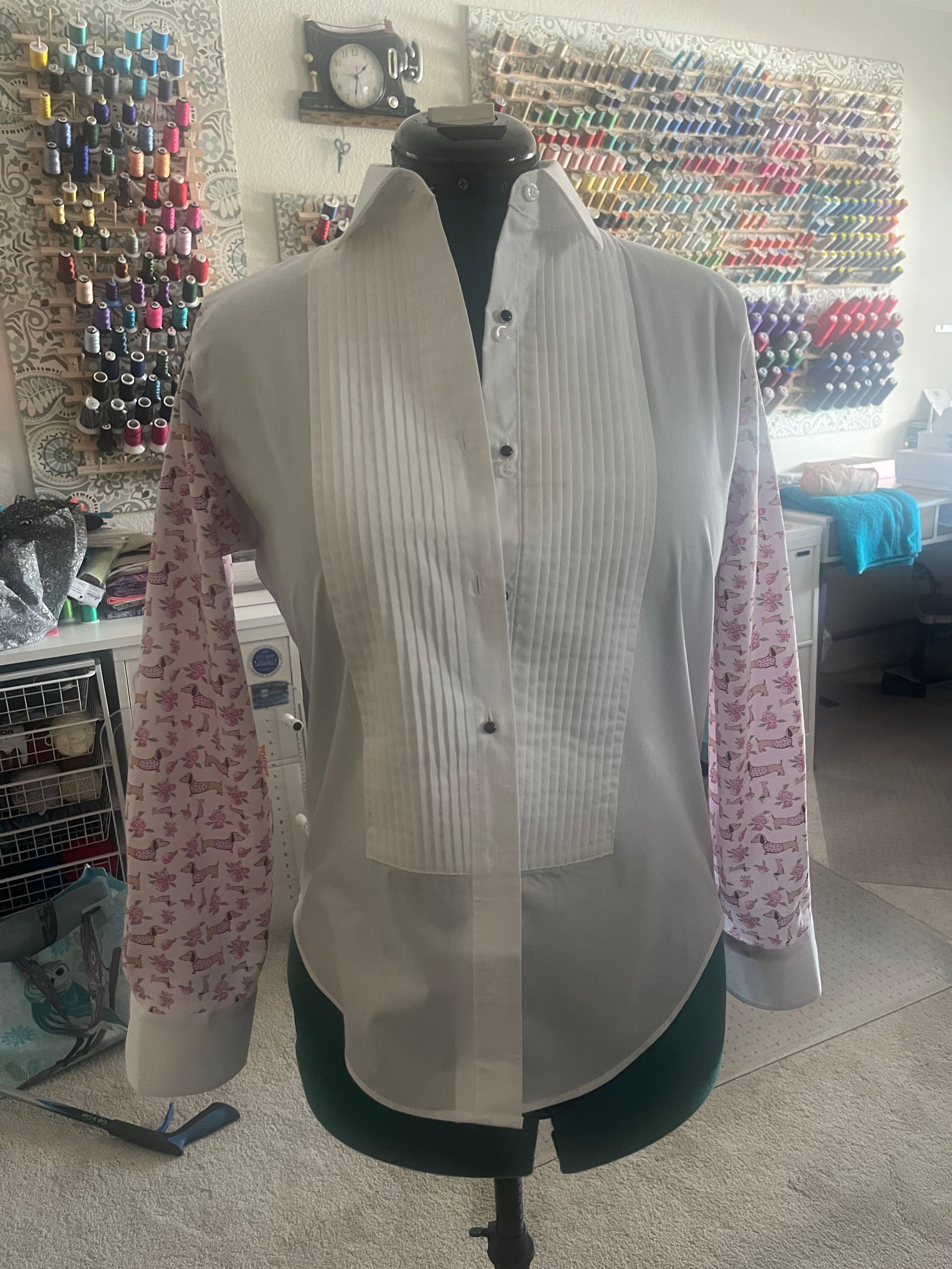 A white shirt is on a mannequin in a sewing room