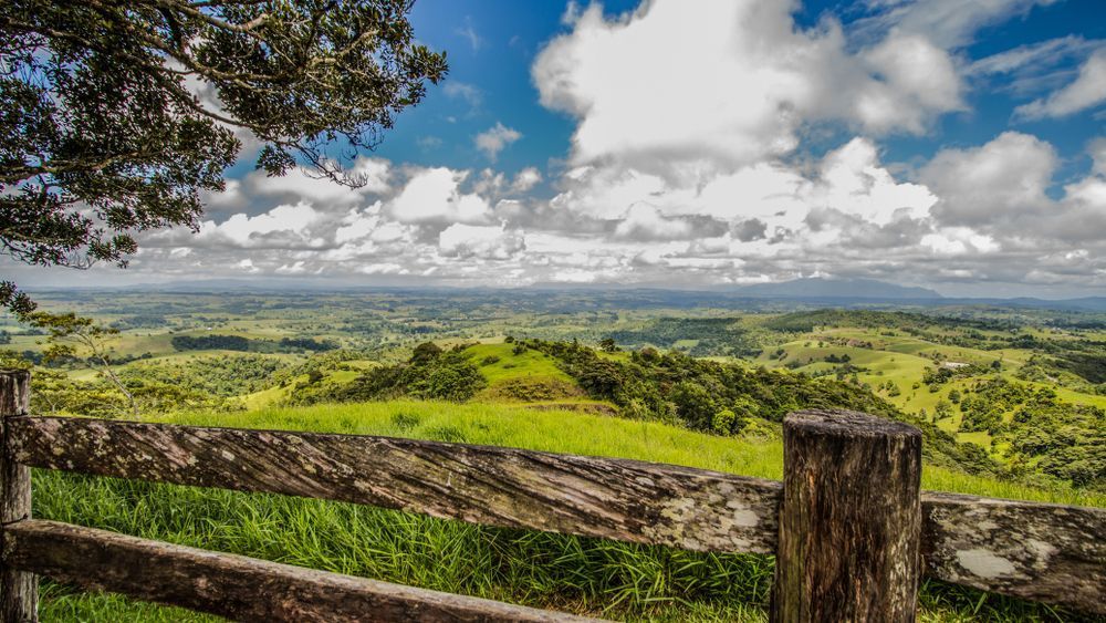 A Wooden Fence With a View of a Lush Green Hillside — Mareeba Floor Coverings Centre in Tablelands, QLD
