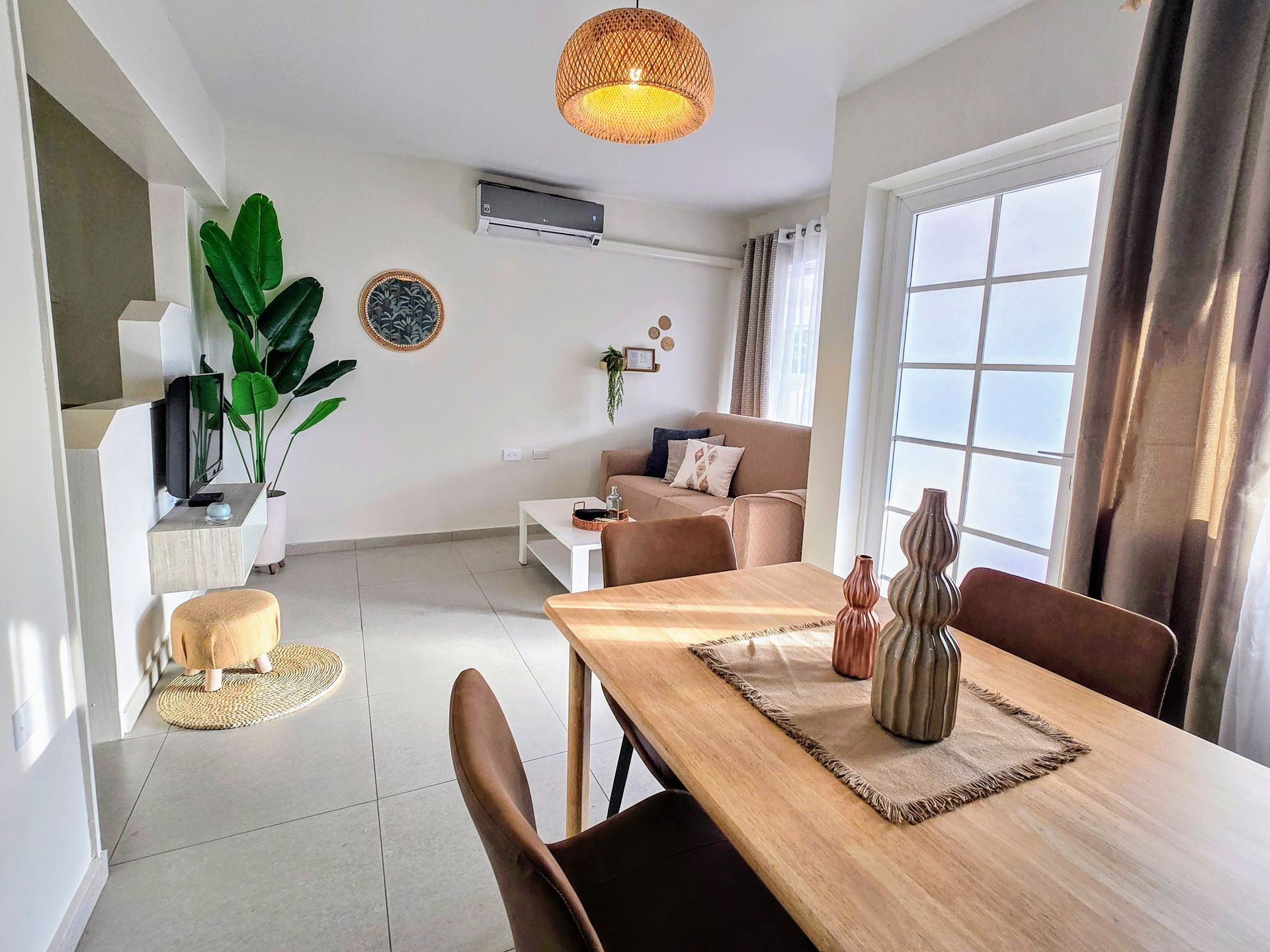 There is a table and chairs on the porch of a house.