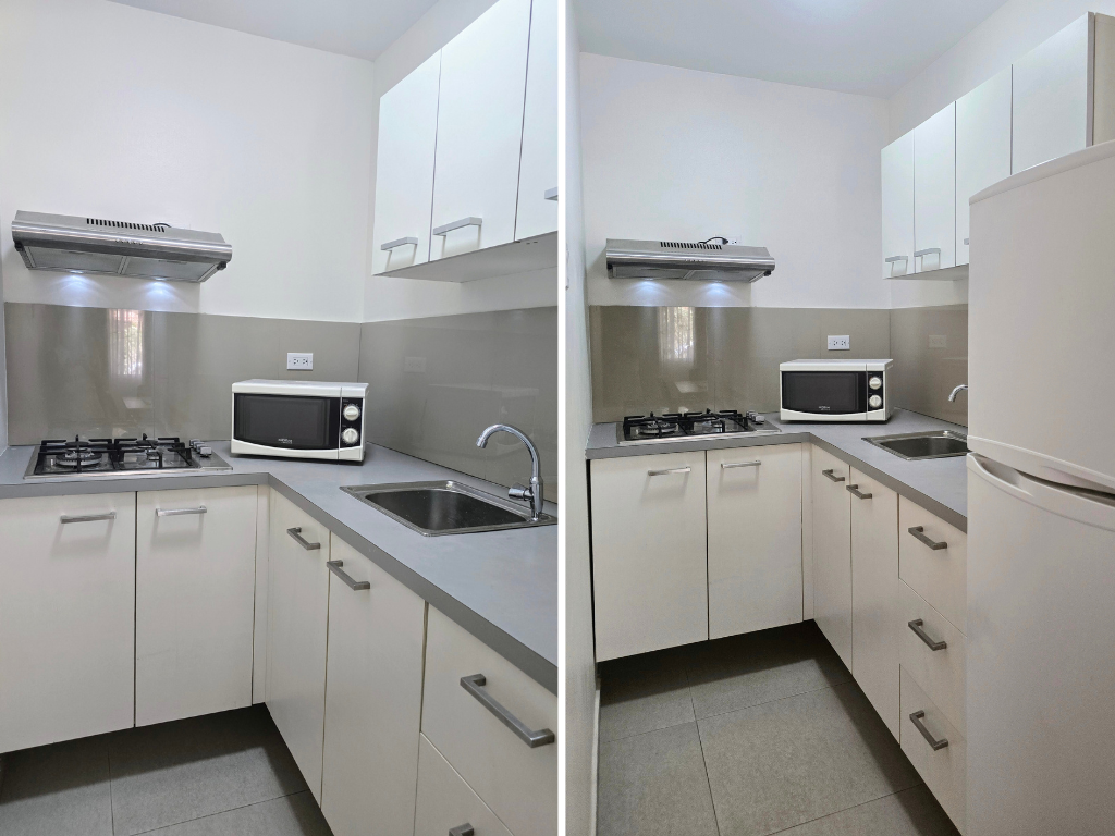 A kitchen with a sink , stove , microwave and refrigerator.