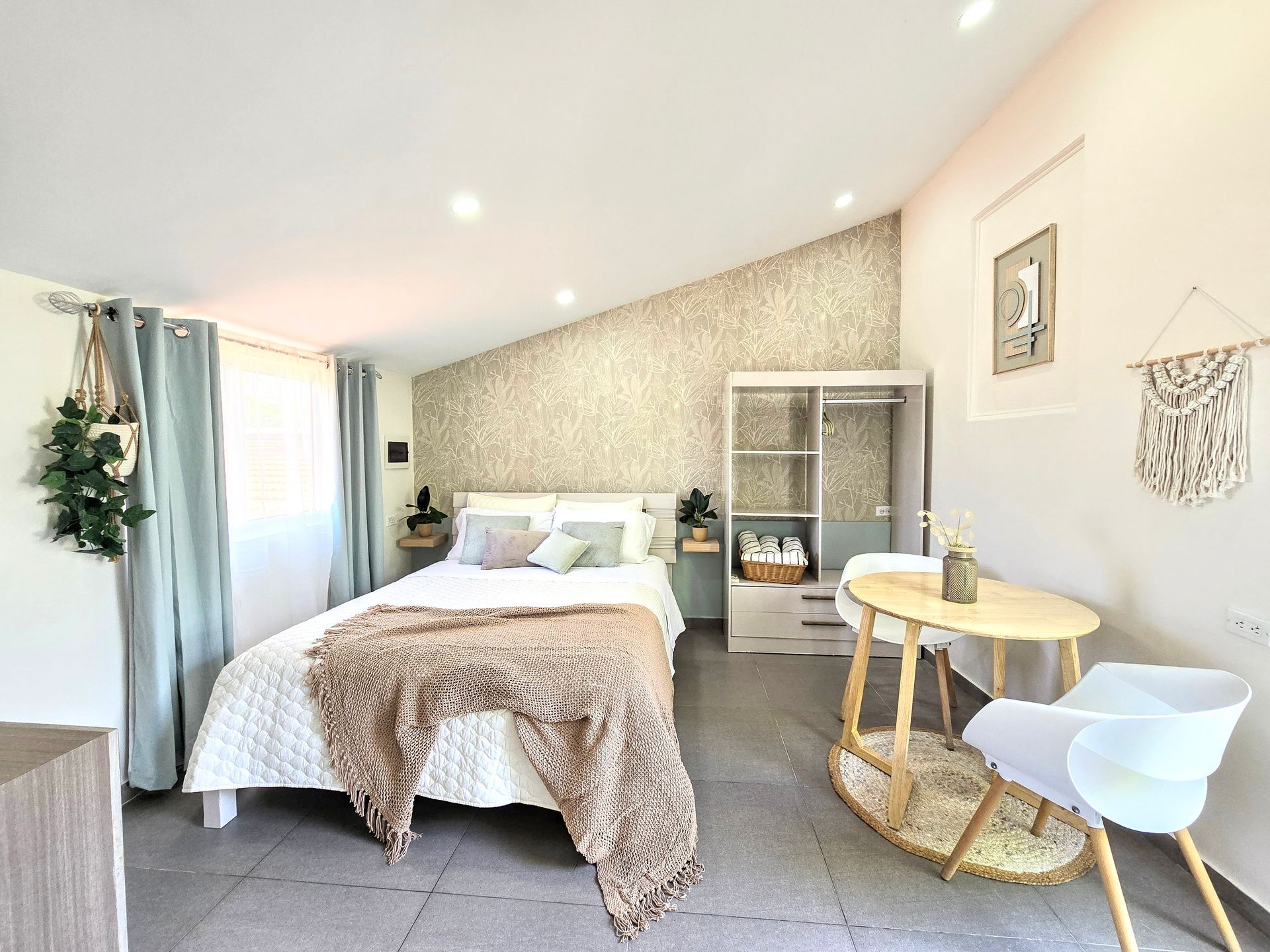 A bedroom with a bed , table and chairs.