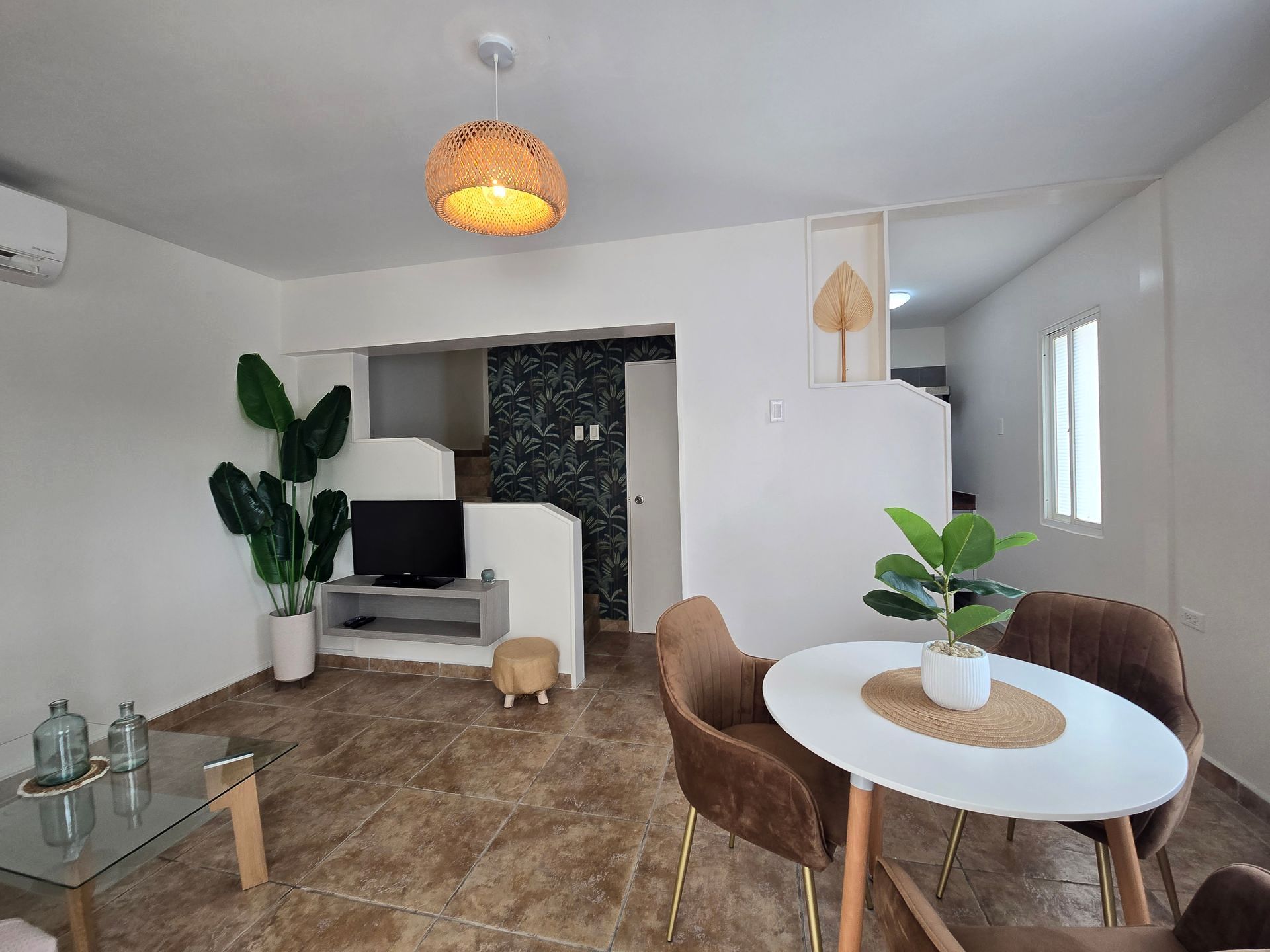 A kitchen with a refrigerator , stove , microwave and a window.