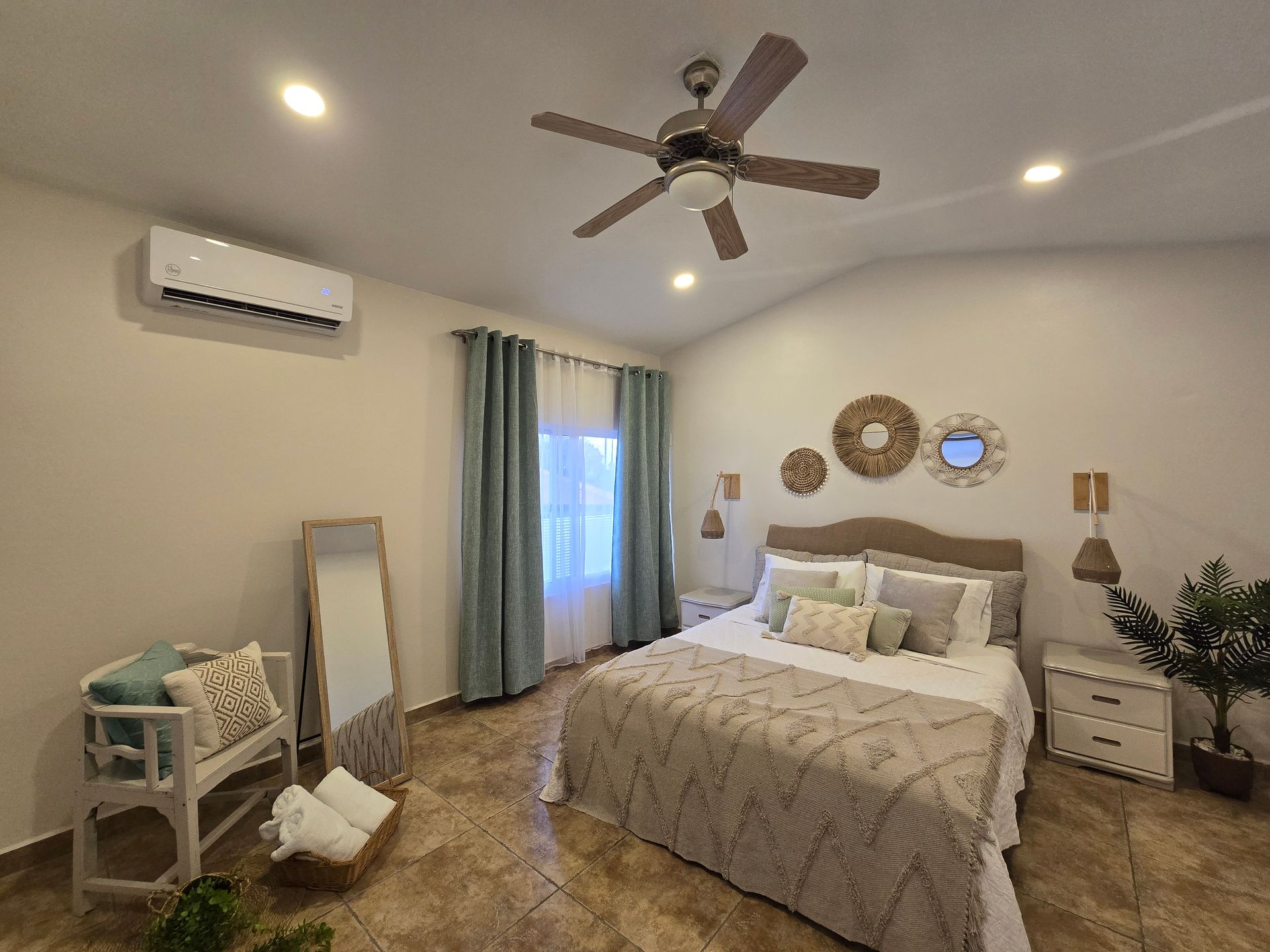 A bedroom with a bed , nightstand , and air conditioner.